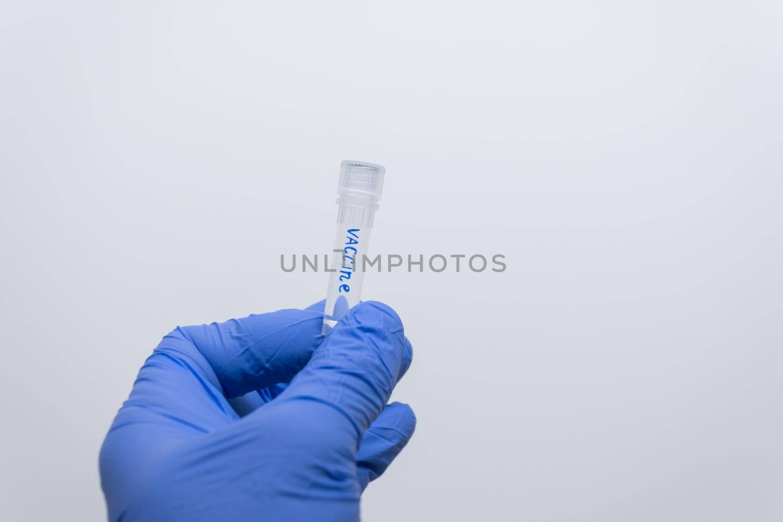 Close-up of a transparent test tube with a vaccine in the doctor’s hand.