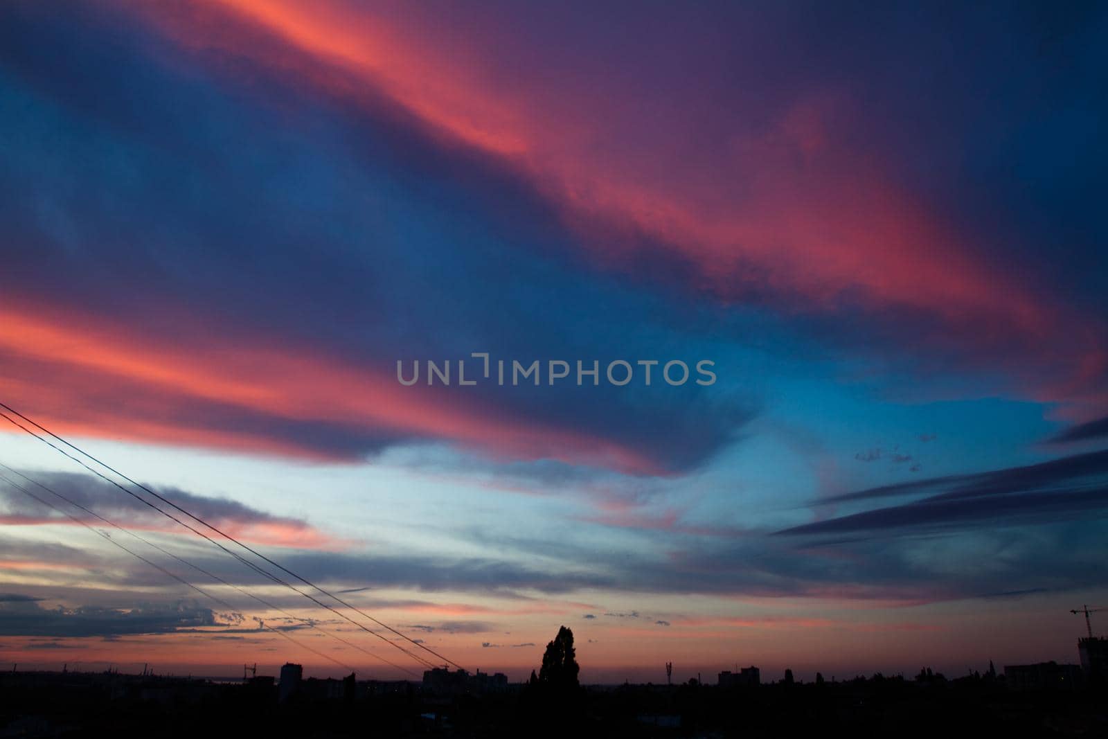Colored clouds at sunset. Clouds over the city. by Jannetta
