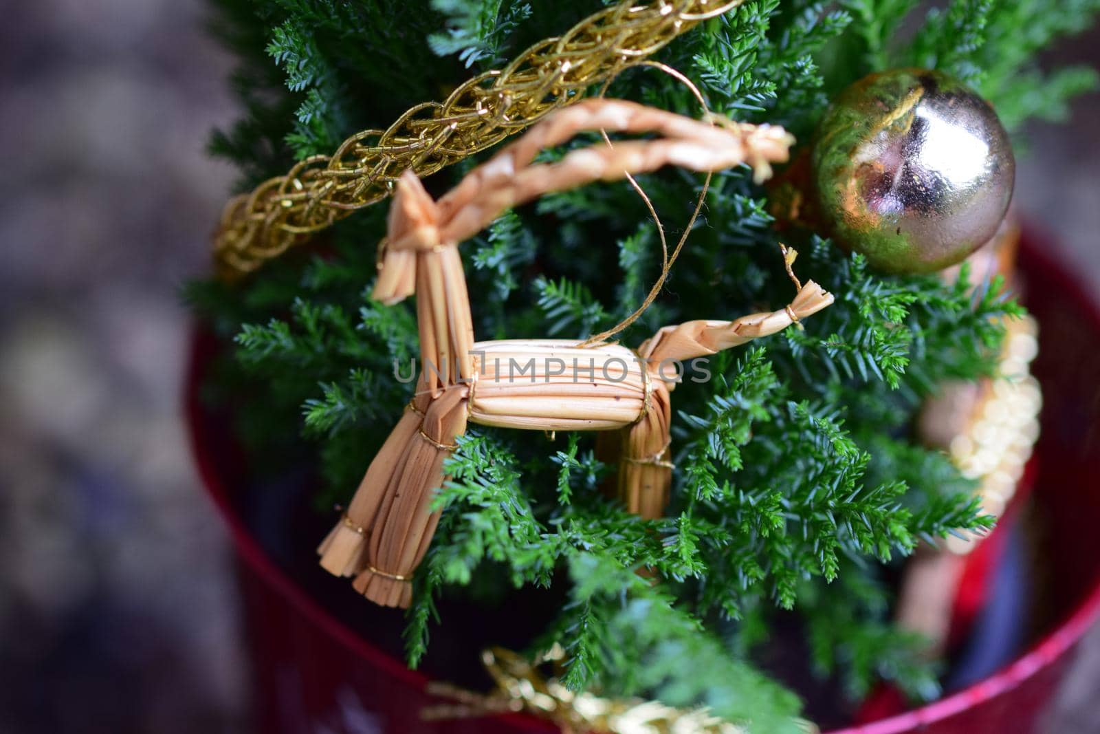 Close up of a straw horse at a small decorated christmas tree