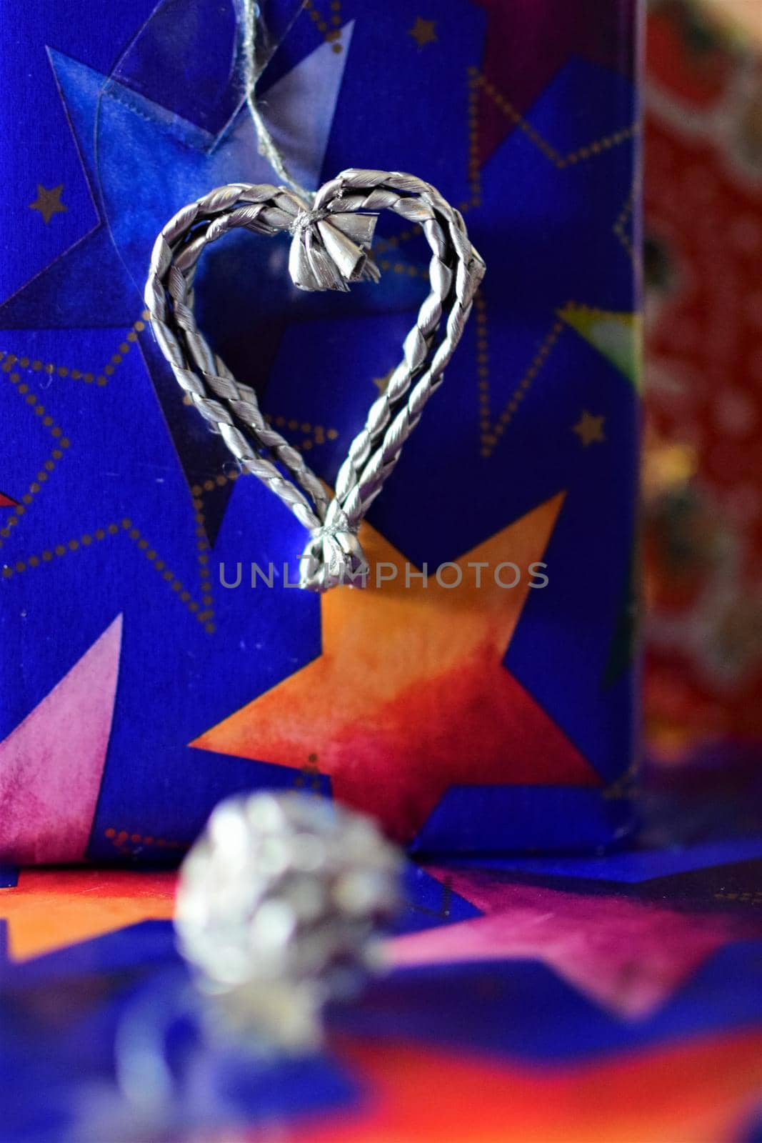 Close up of colorful christmas gifts with a silver colored heart by Luise123