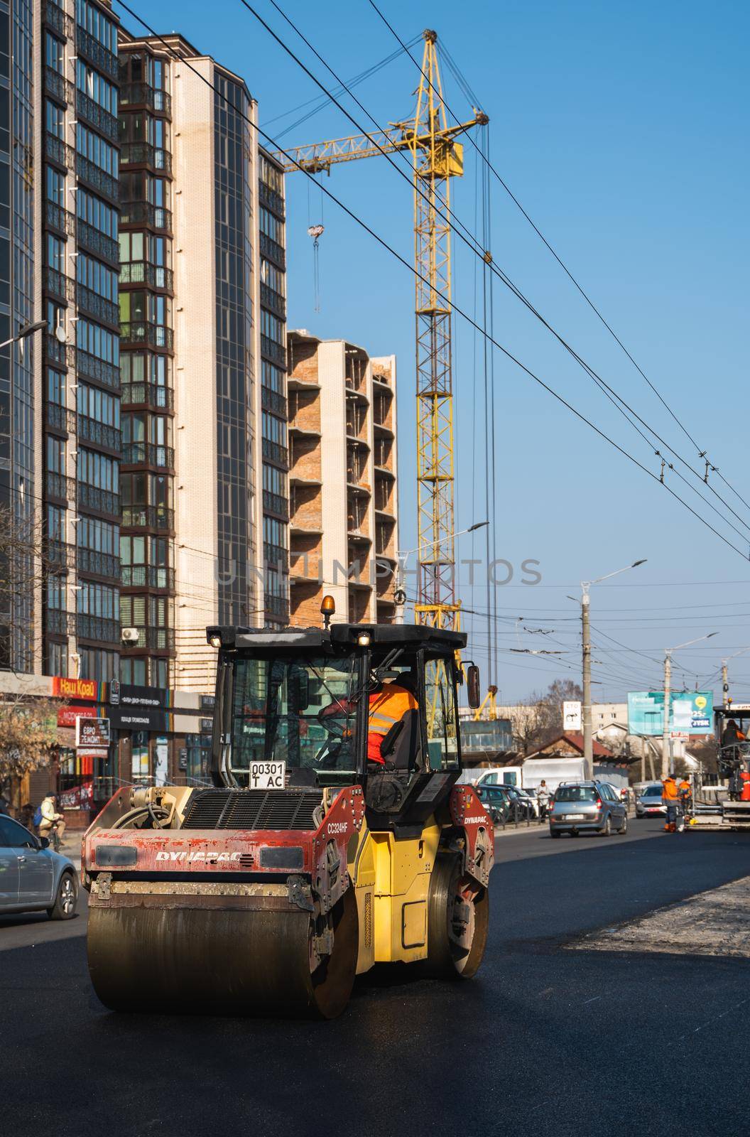 KYIV, UKRAINE - September 10, 2020: Heavy asphalt road roller with heavy vibration roller compactor that press new hot asphalt on the roadway on a road construction site on a street