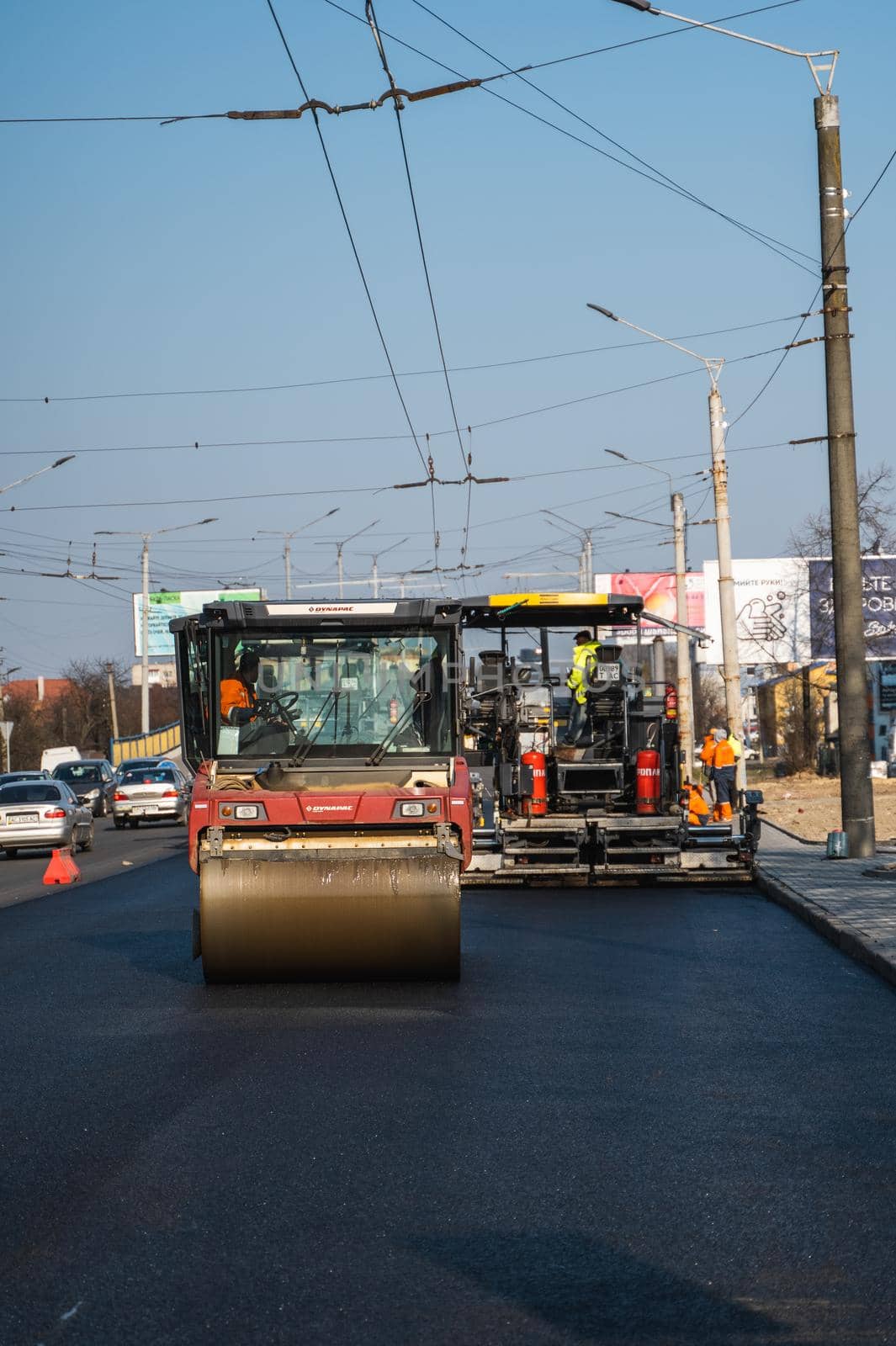 KYIV, UKRAINE - September 10, 2020: Heavy asphalt road roller with heavy vibration roller compactor that press new hot asphalt on the roadway on a road construction site on a street