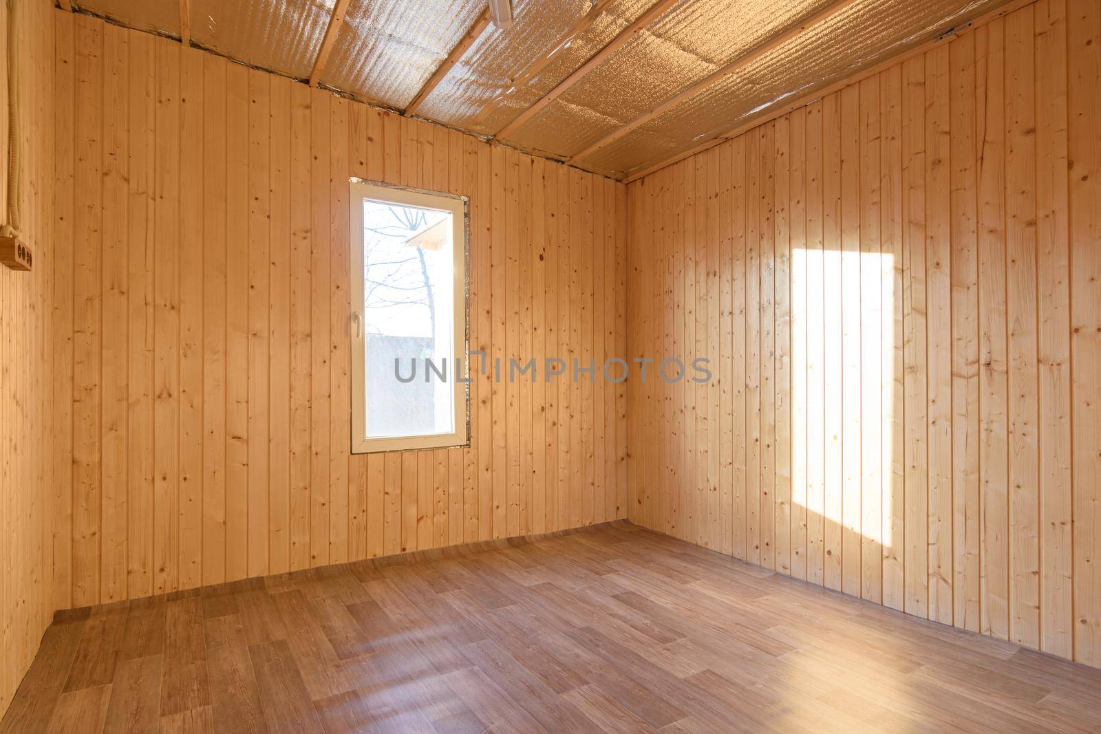 Empty room in a country house, sun rays fall on the wall from the window