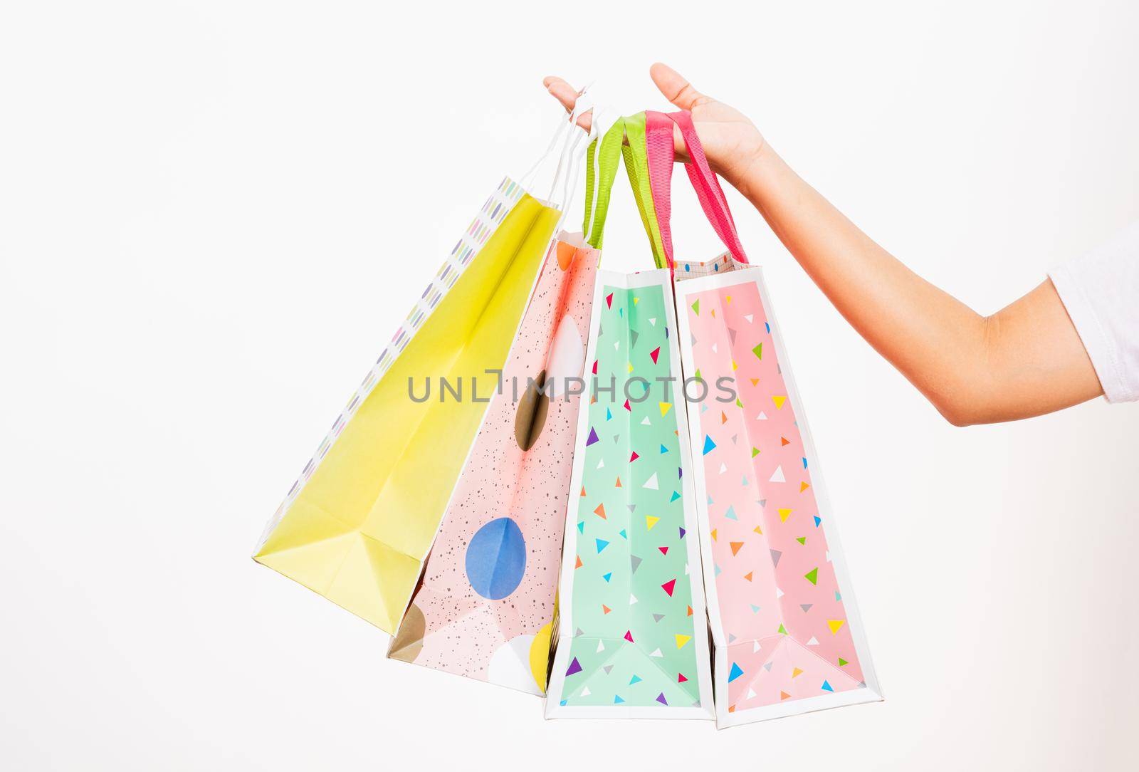 women hand holding colorful multicolor shopping bag many packets by Sorapop