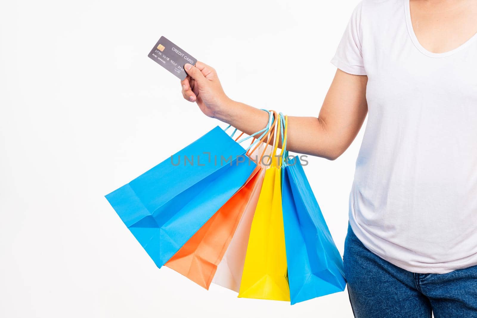 Happy woman hand holding shopping bags multicolor and credit card for shopping online, young female hold many packets within arms isolated on white background, Black Friday sale concept