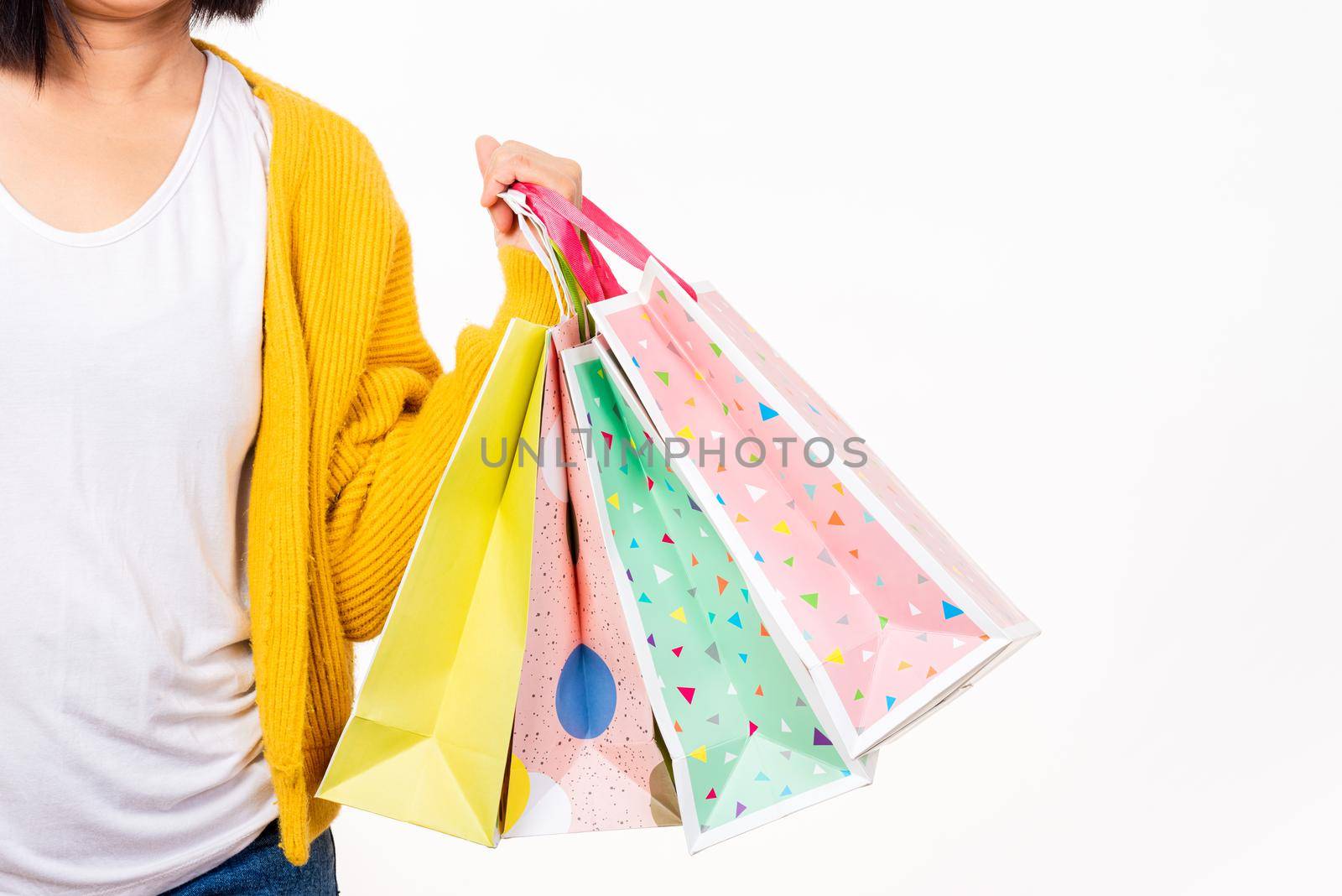 Happy woman hand she wears yellow shirt holding shopping bags multicolor, young female hold many packets within arms isolated on white background, Black Friday sale concept