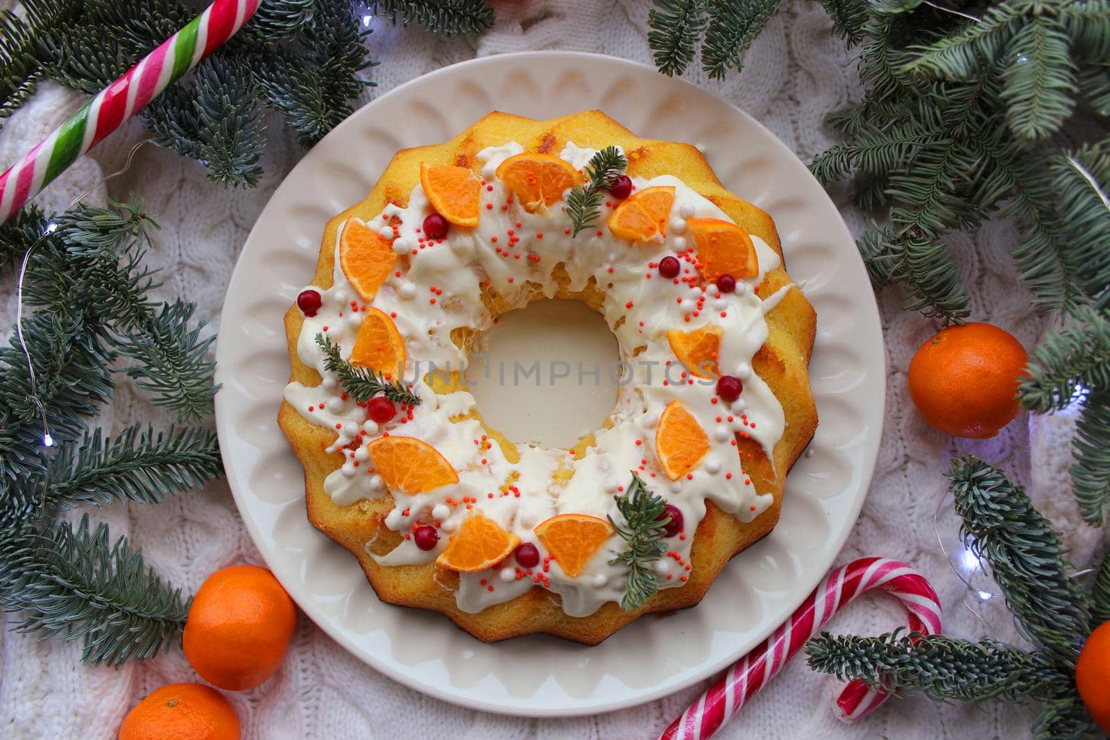 New year round cupcake with a Cup of tea decorated with tangerine slices and lollipops on the table