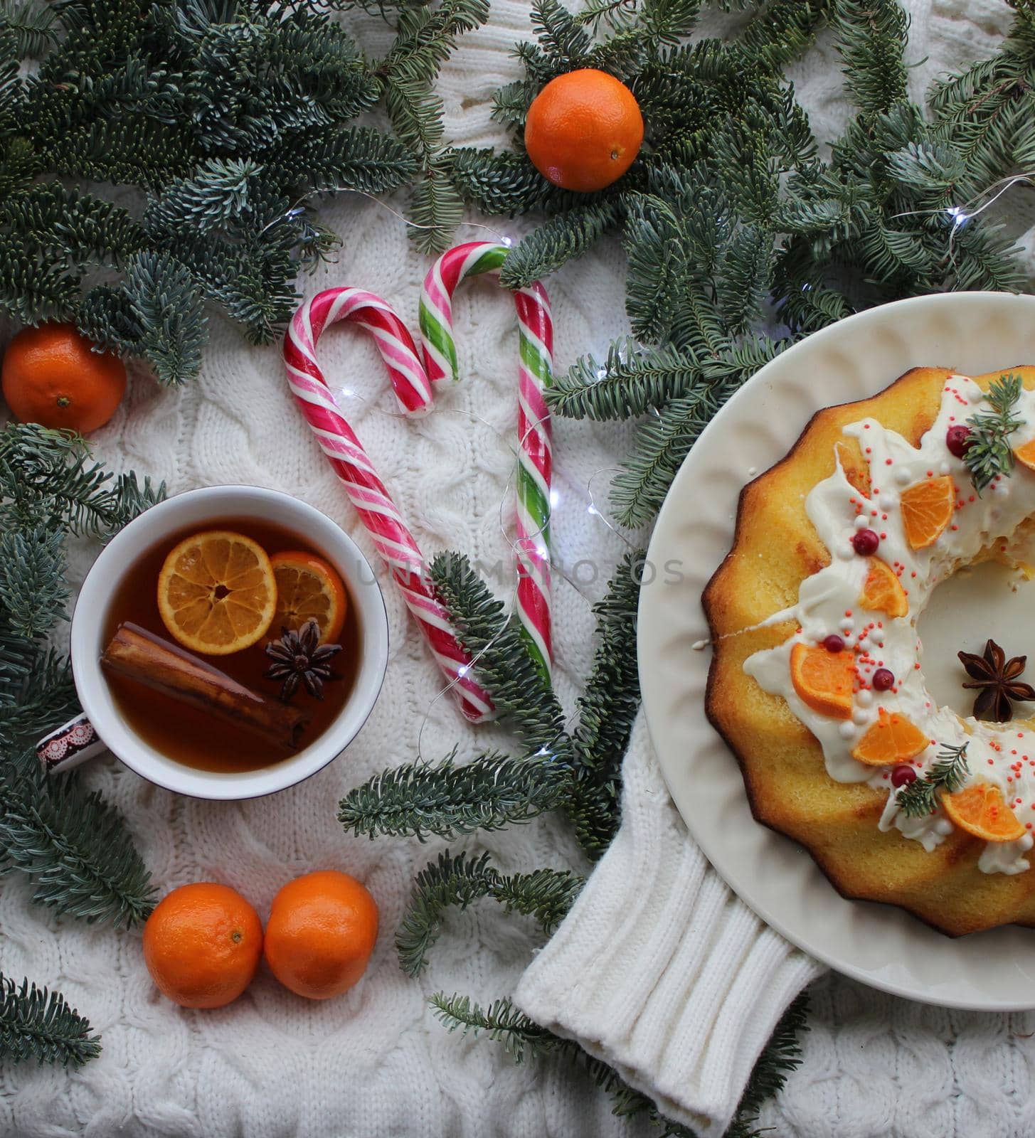 New year's dessert with a Cup of tea is decorated with tangerine slices and lollipops on the table