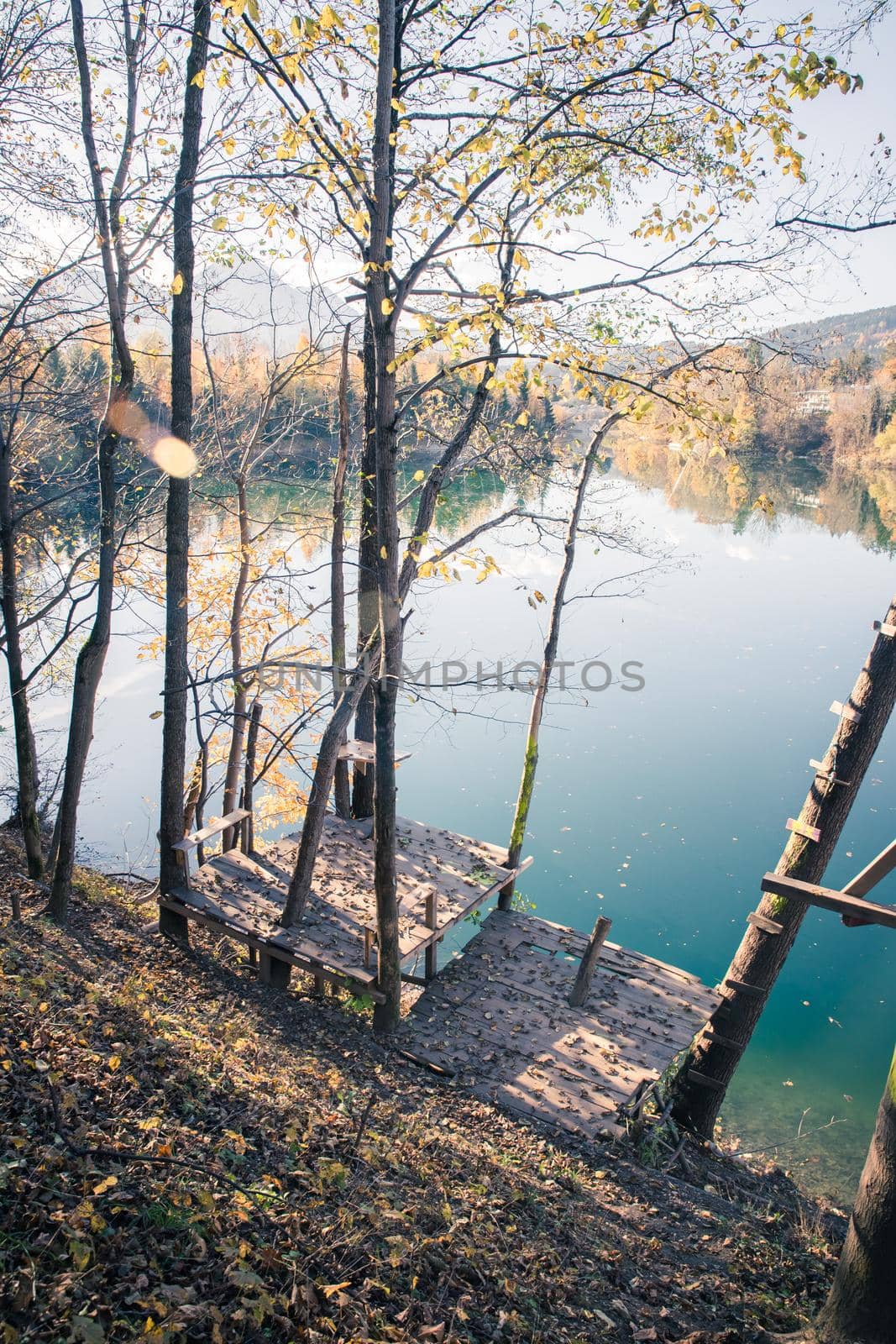Autumn scenery: Footbridge and a blue lake, colourful laves
