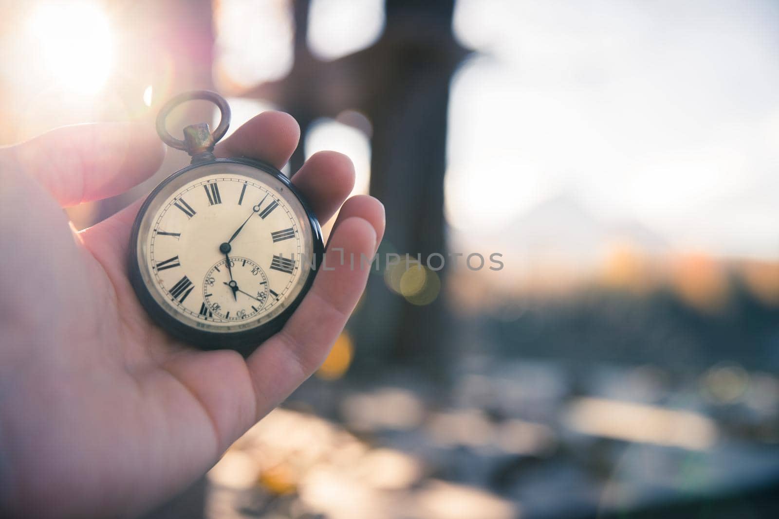 Hand held stop watch outdoors, autumn, blurry background