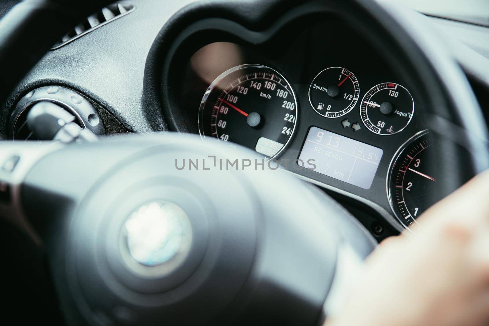 Female hands on a sports car steering wheel, car interior