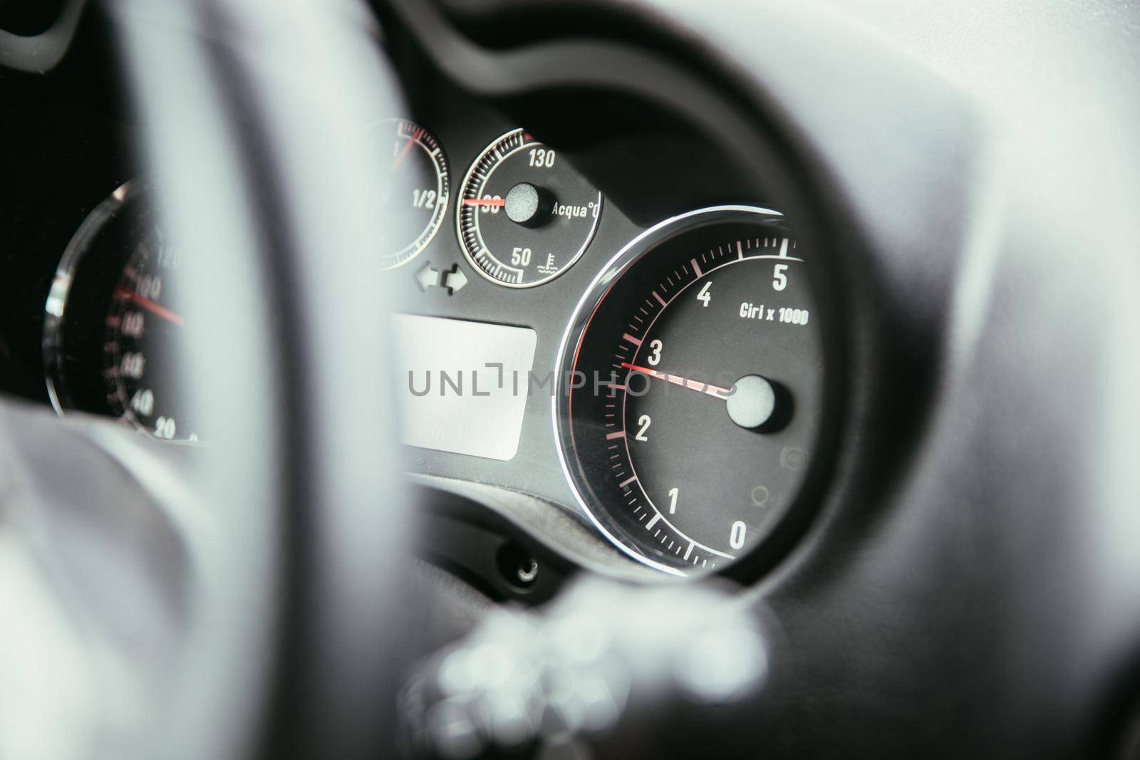 Dashboard of a sports car, steering wheel blurry