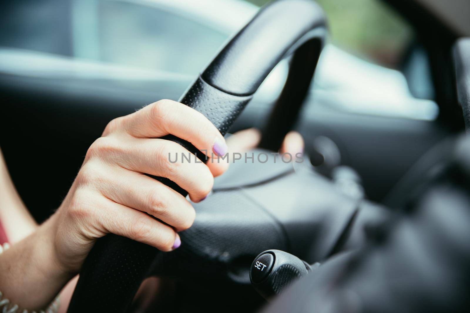 Female hands on a sports car steering wheel, car interior