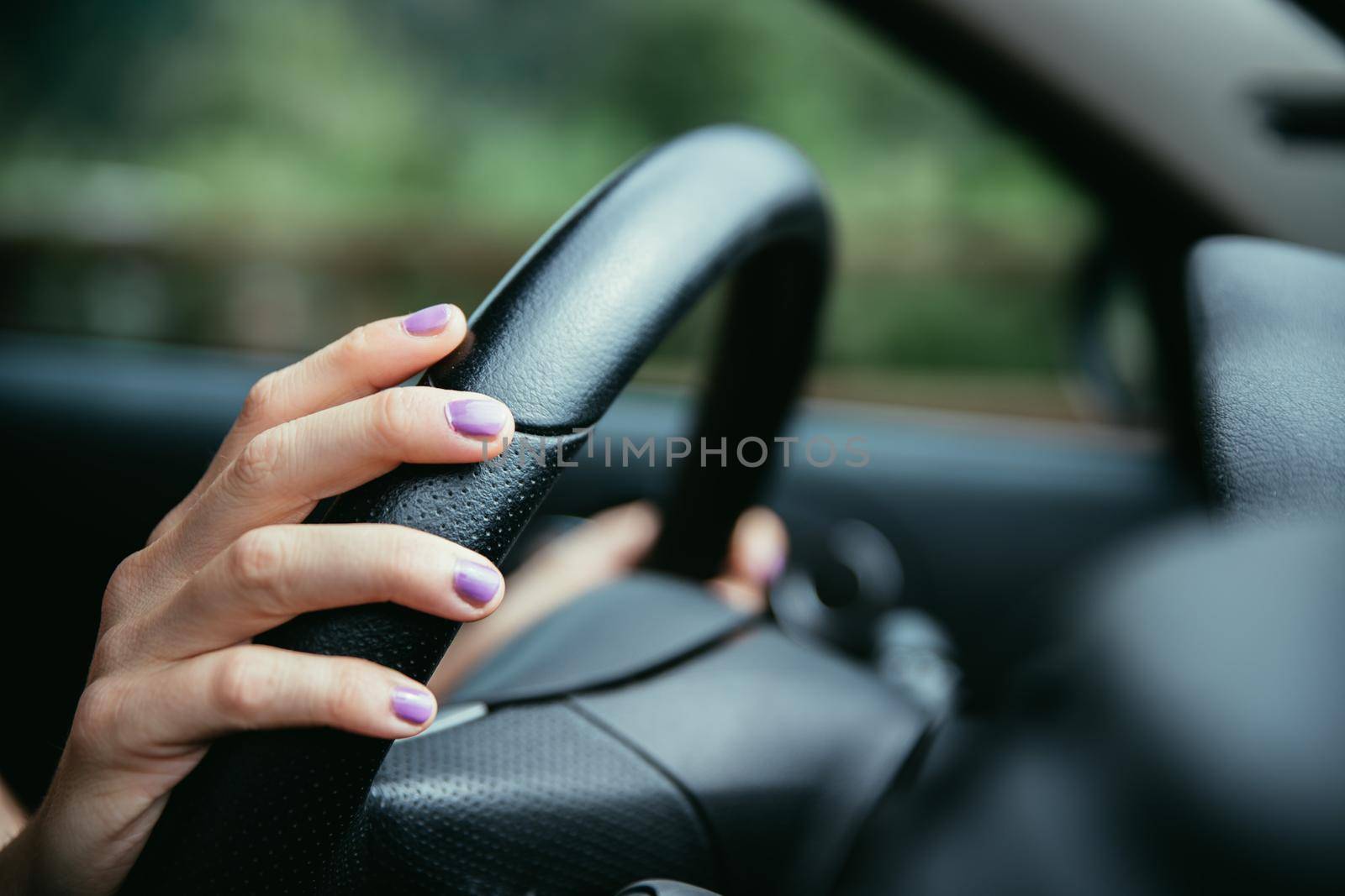 Sports car steering wheel, woman is driving