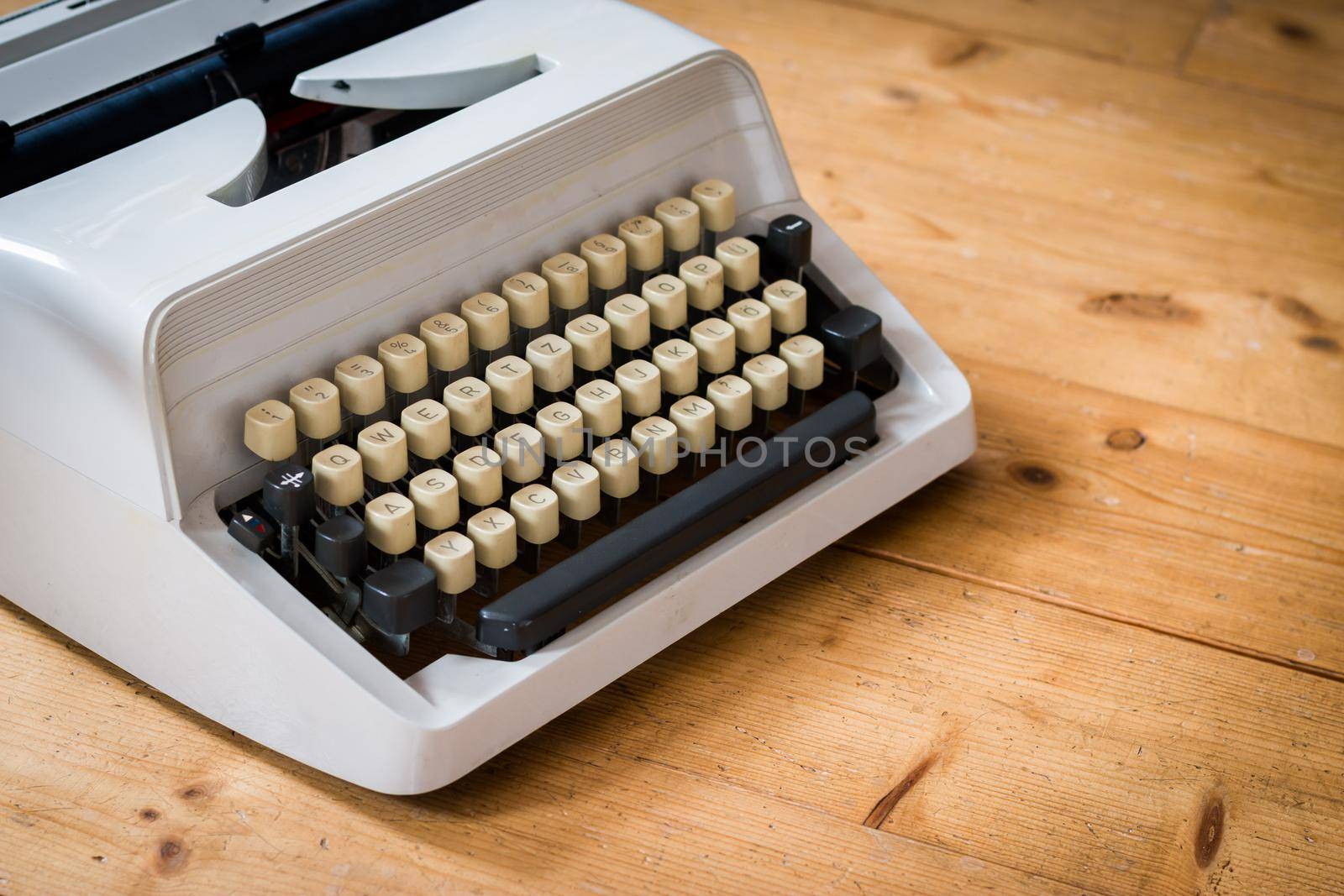 Old fashioned vintage typewriter on wood desk by Daxenbichler