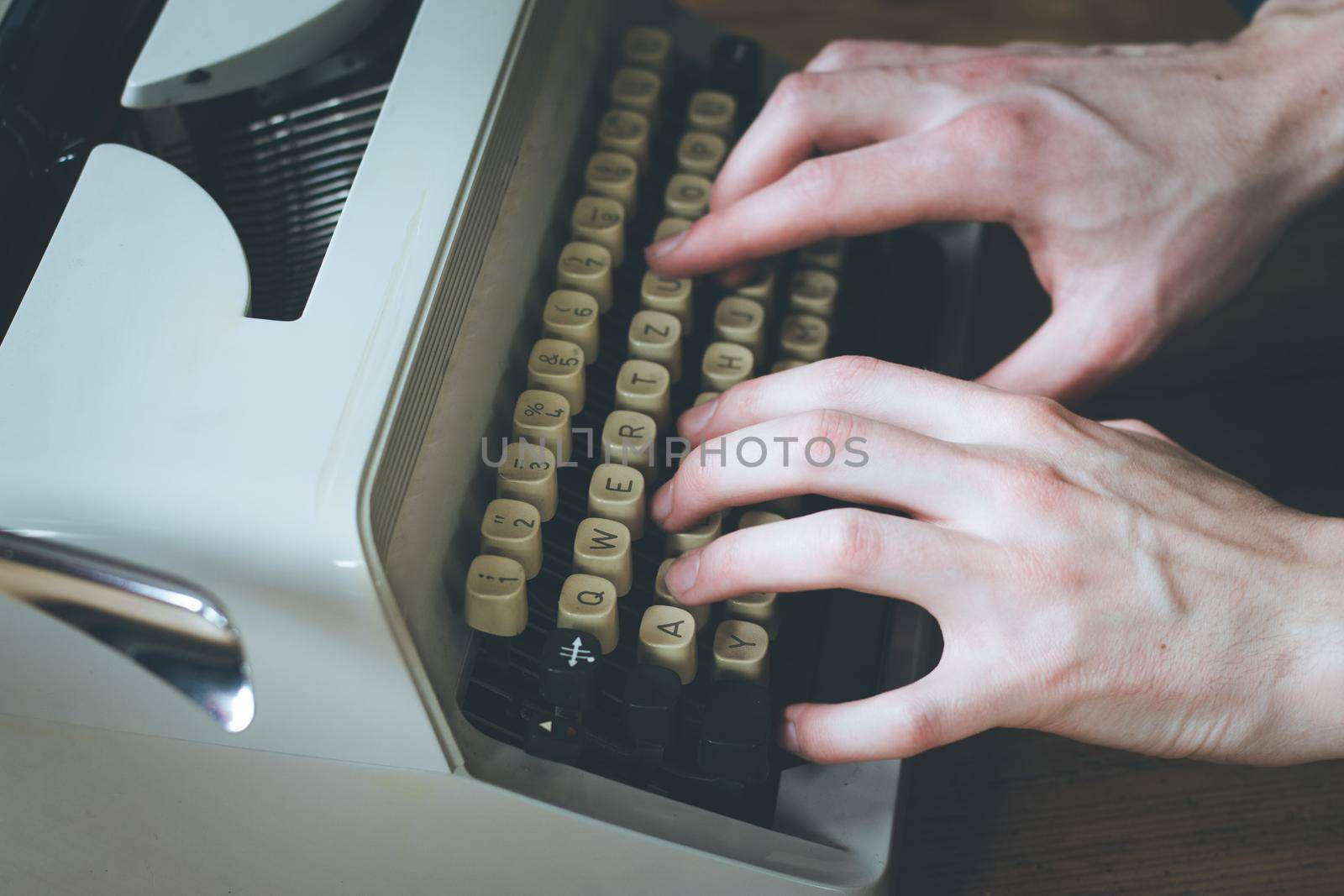 Man is typing on a vintage typewriter by Daxenbichler