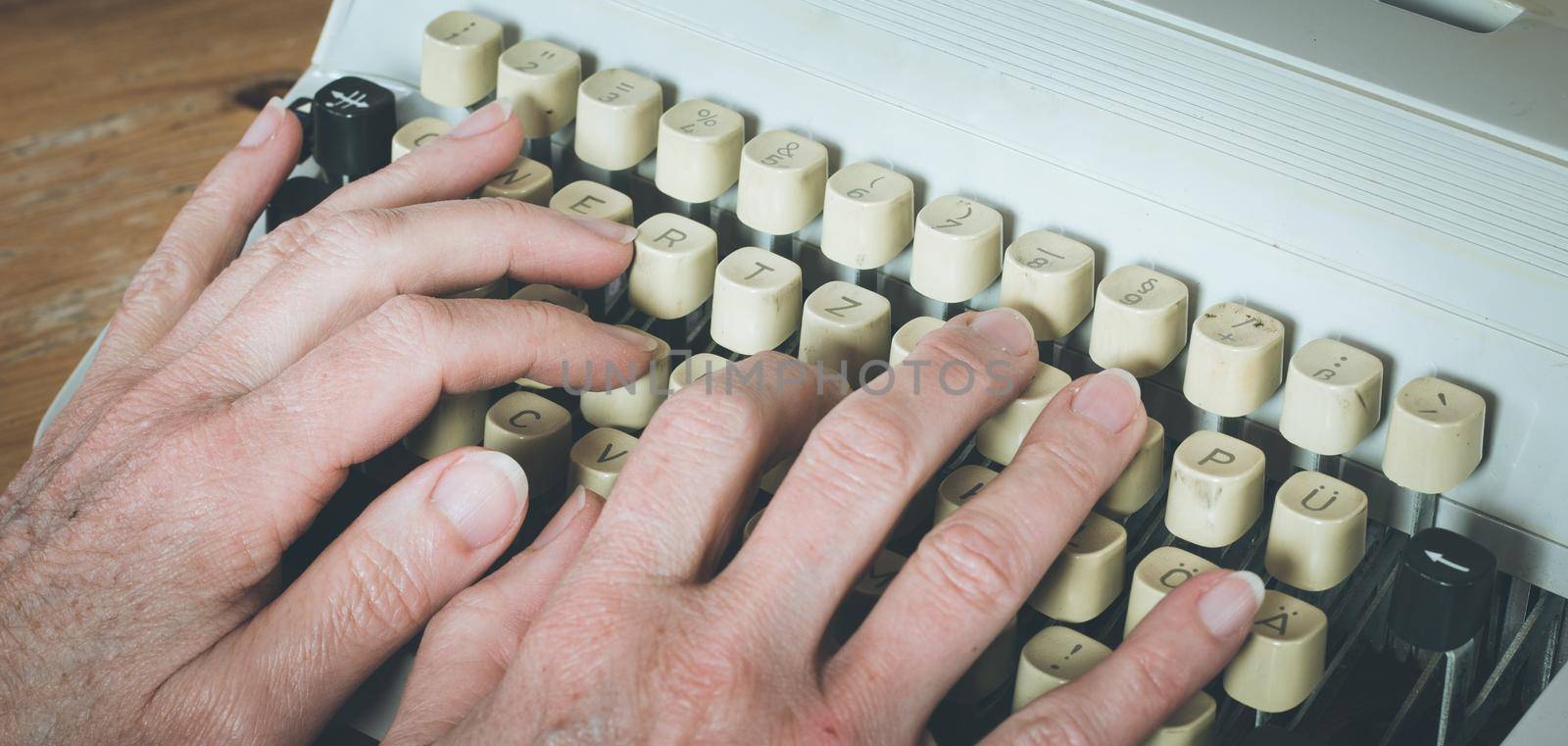 Man is typing on a vintage typewriter by Daxenbichler