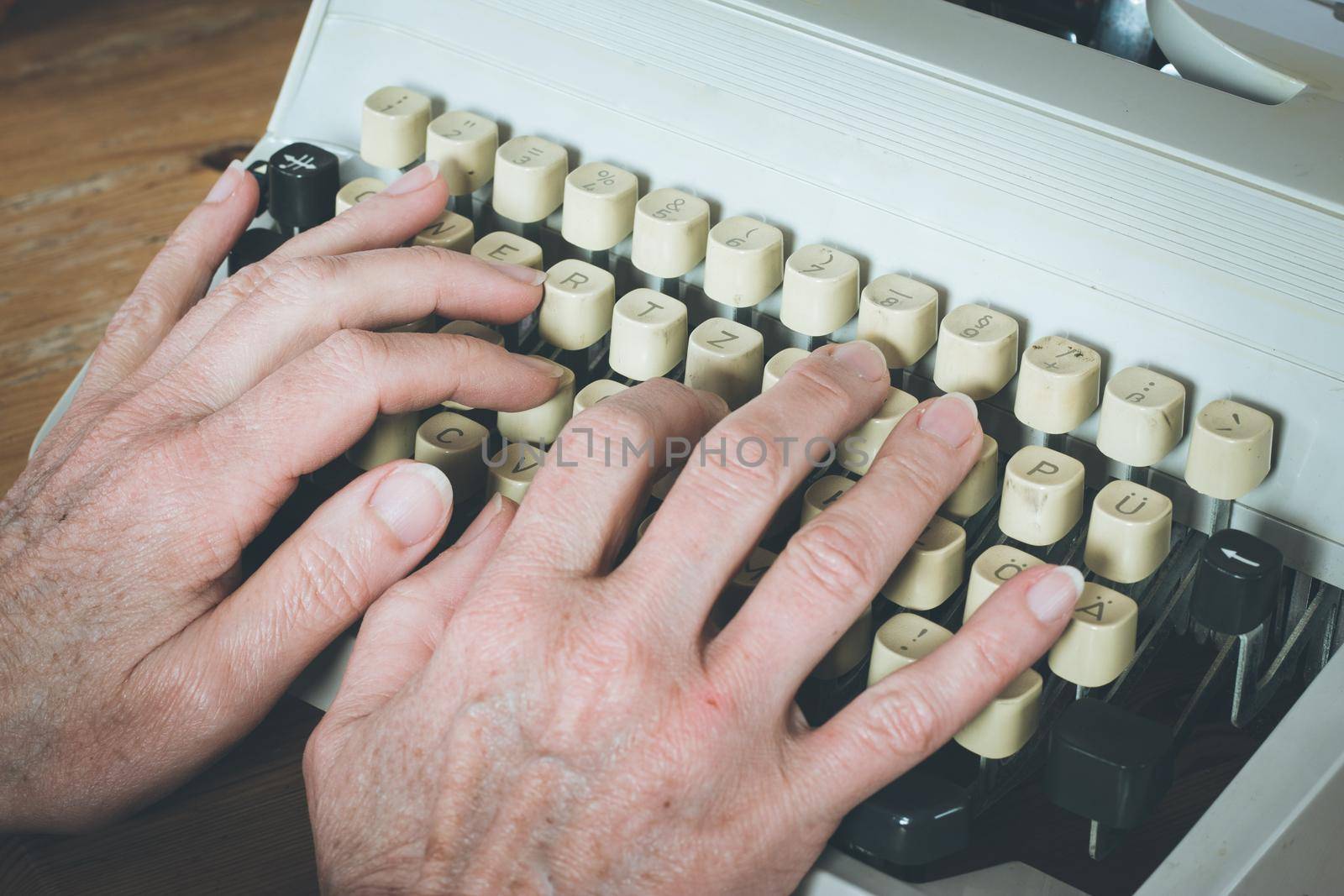 Old fashioned vintage typewriter on wood desk by Daxenbichler