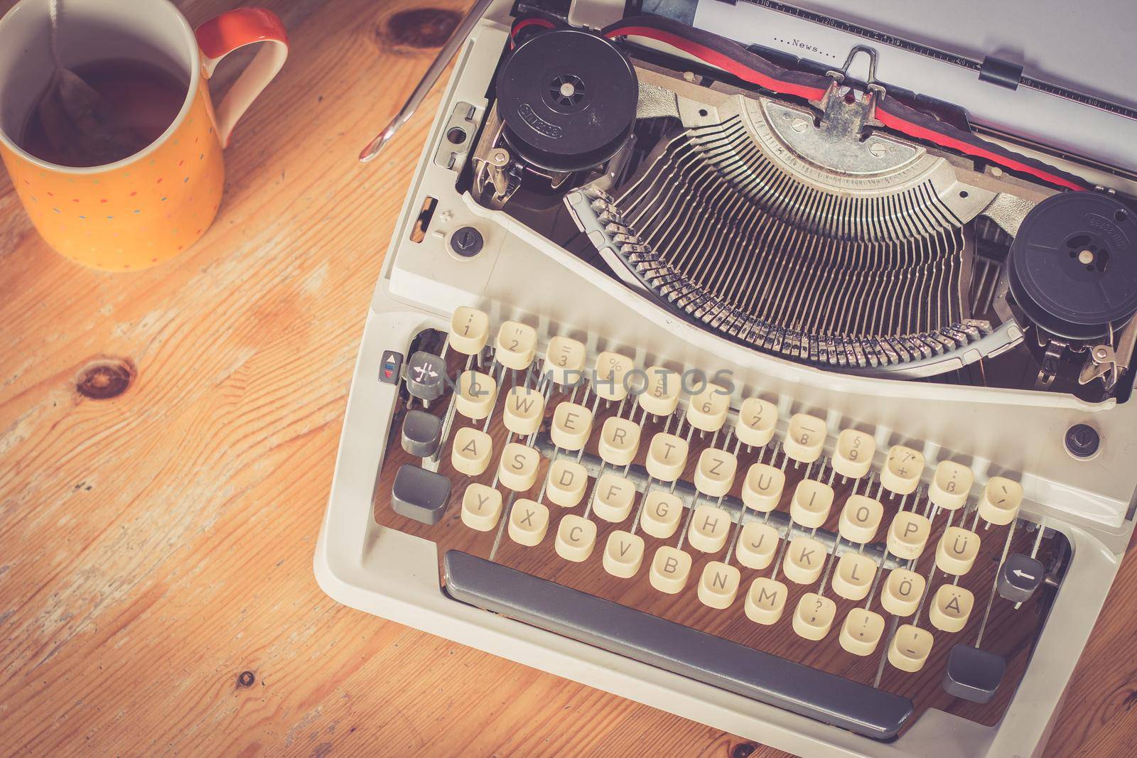 Vintage typewriter, glasses and cup of coffee on a wood desk