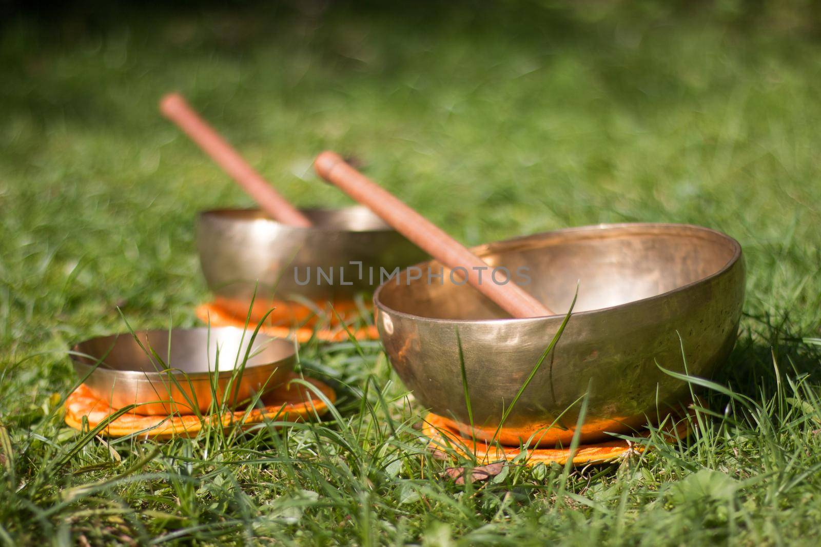 Set of metal singing bowls in the grass of the own garden, zen