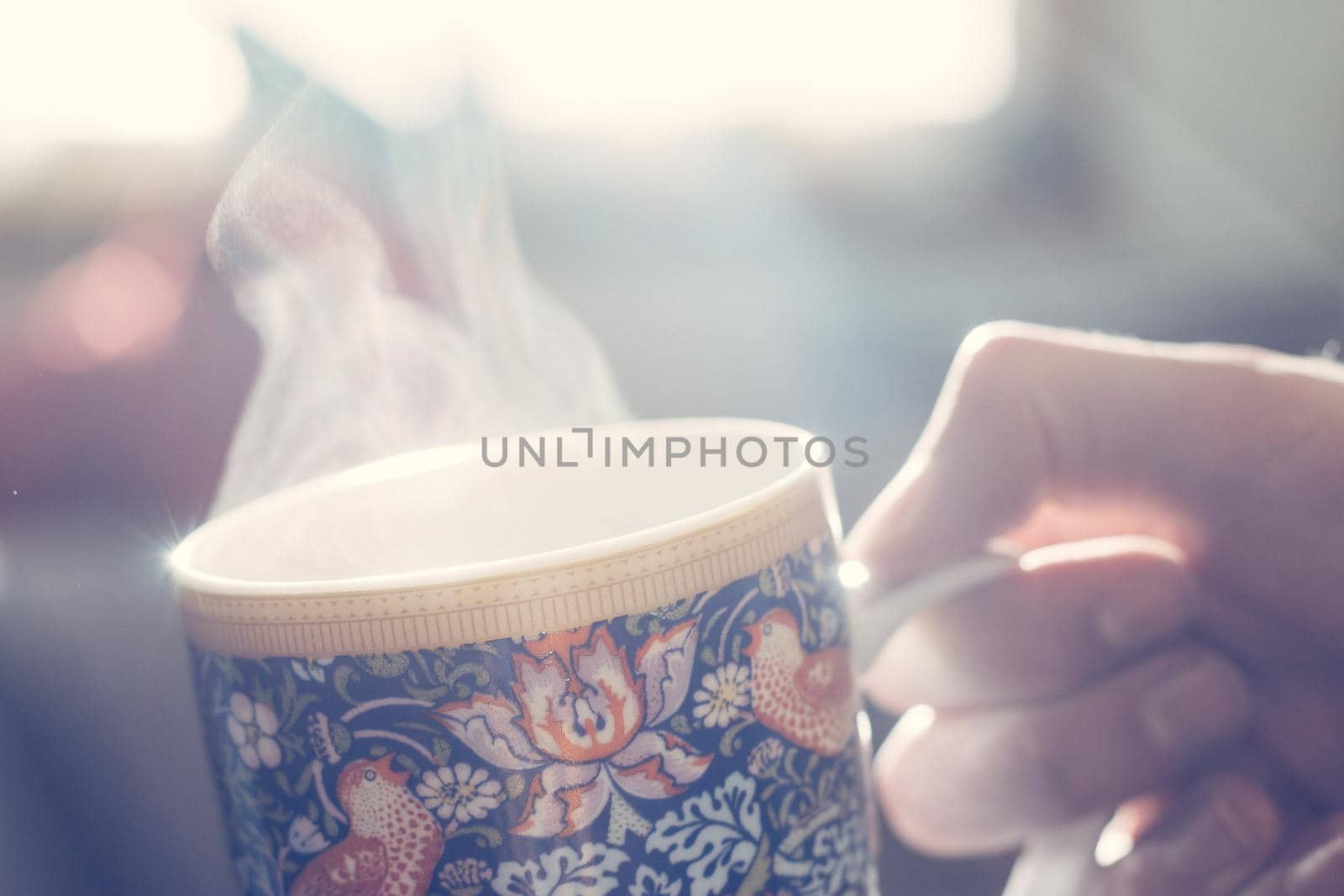 Steaming tea cup and sunlight, warm-up in winter