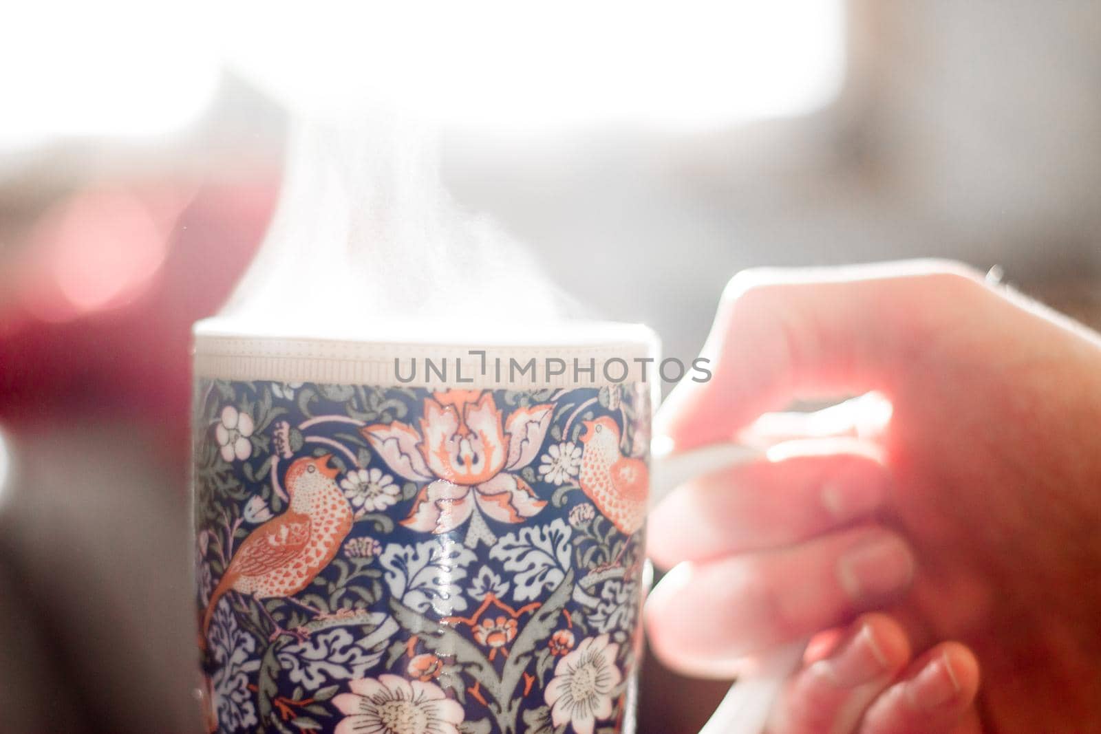 Steaming tea cup and sunlight, warm-up in winter