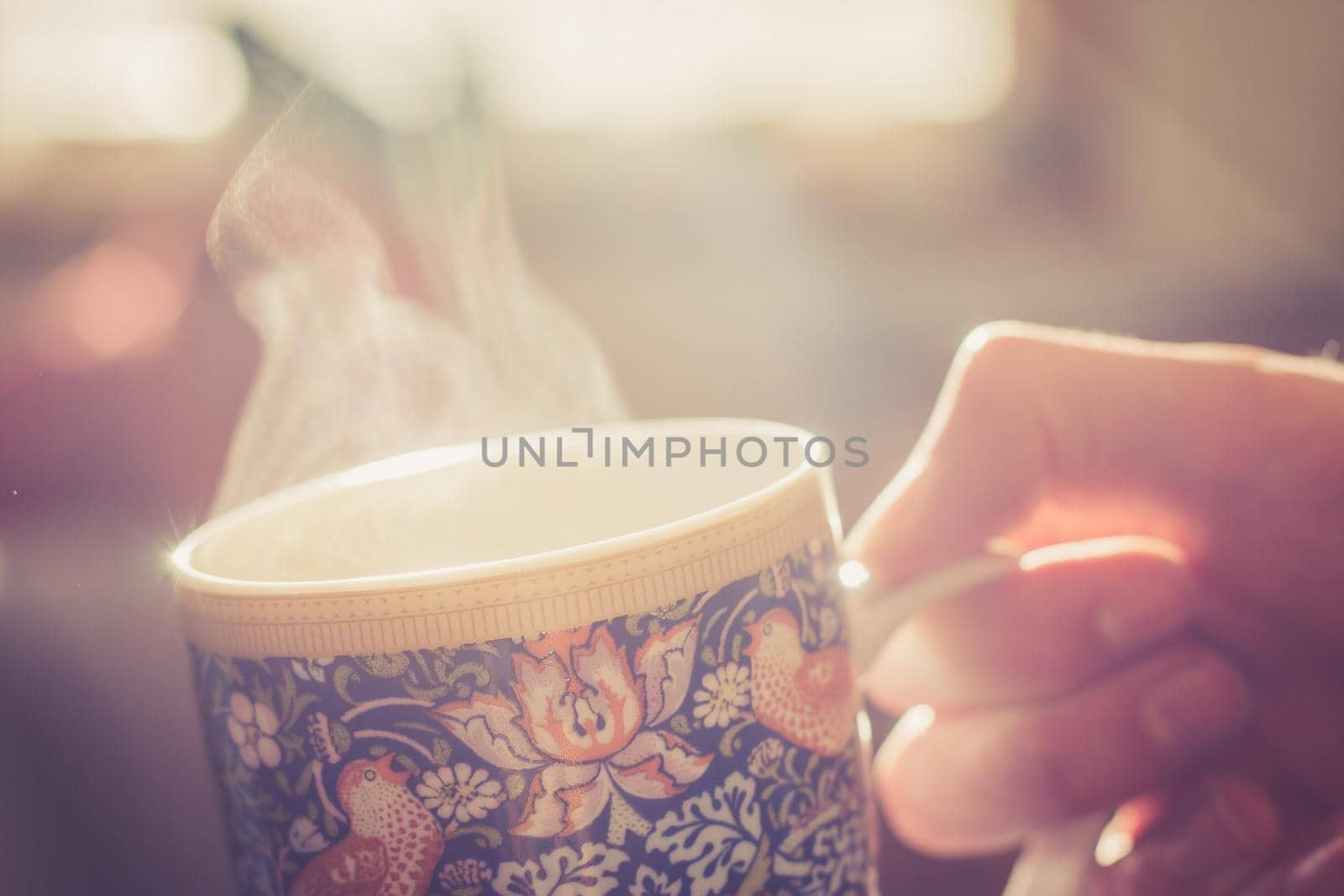 Steaming tea cup and sunlight, warm-up in winter