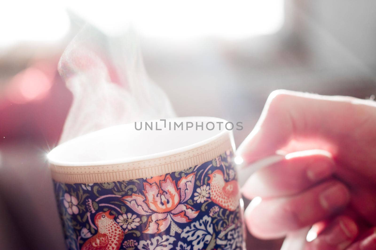Steaming tea cup and sunlight, warm-up in winter