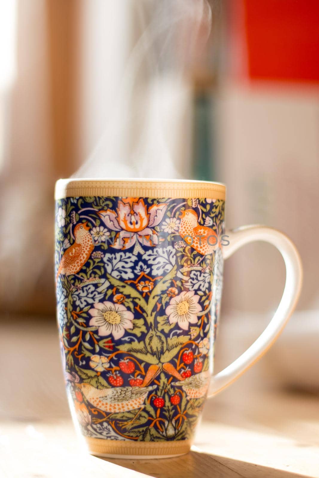 Steaming tea cup and sunlight, warm-up in winter