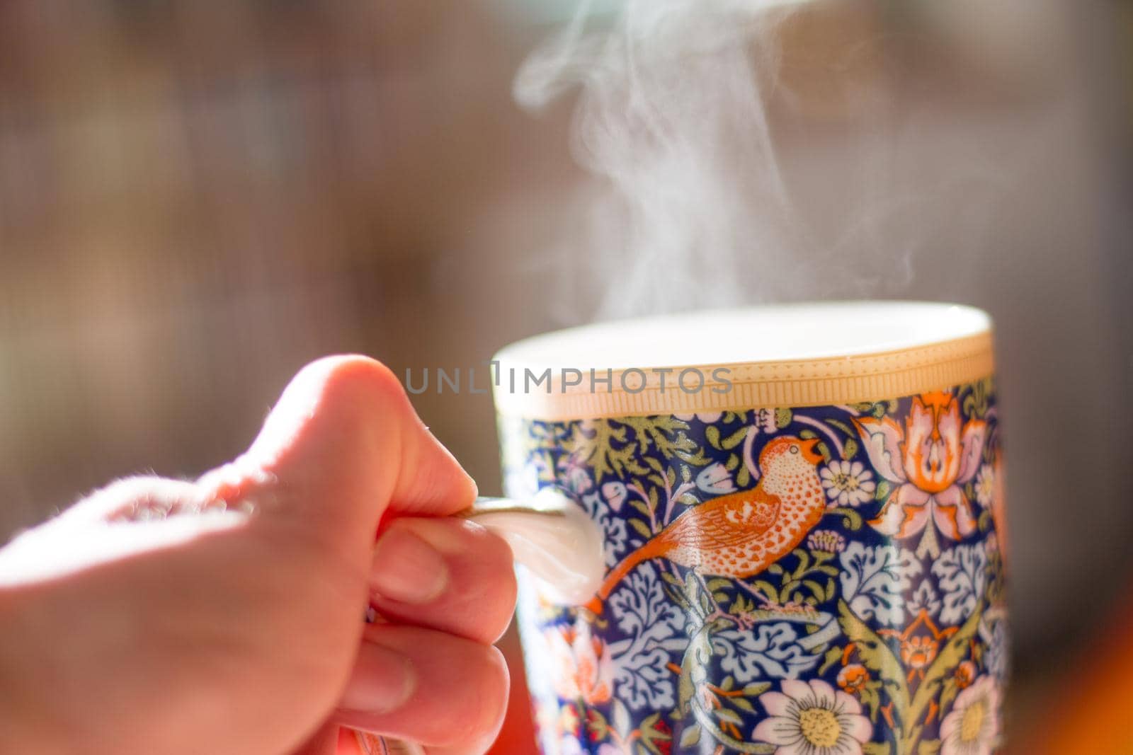 Steaming tea cup and sunlight, warm-up in winter