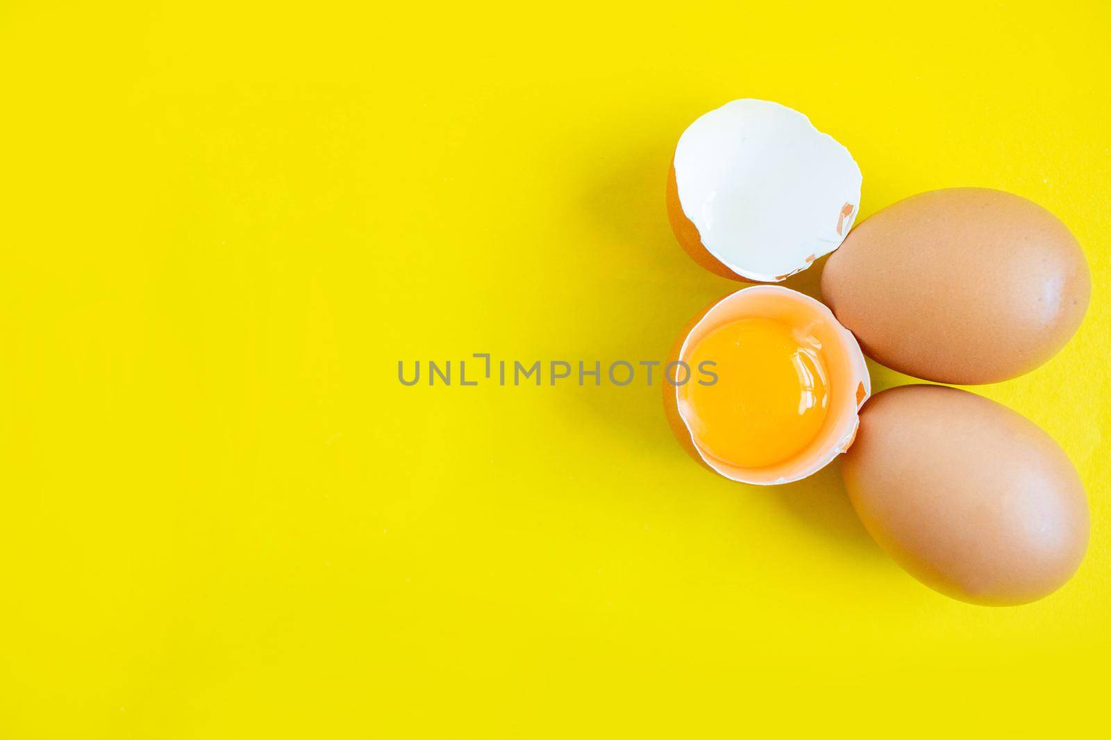 Closeup cracked brown eggs Buy from supermarket Placed on a yellow background.