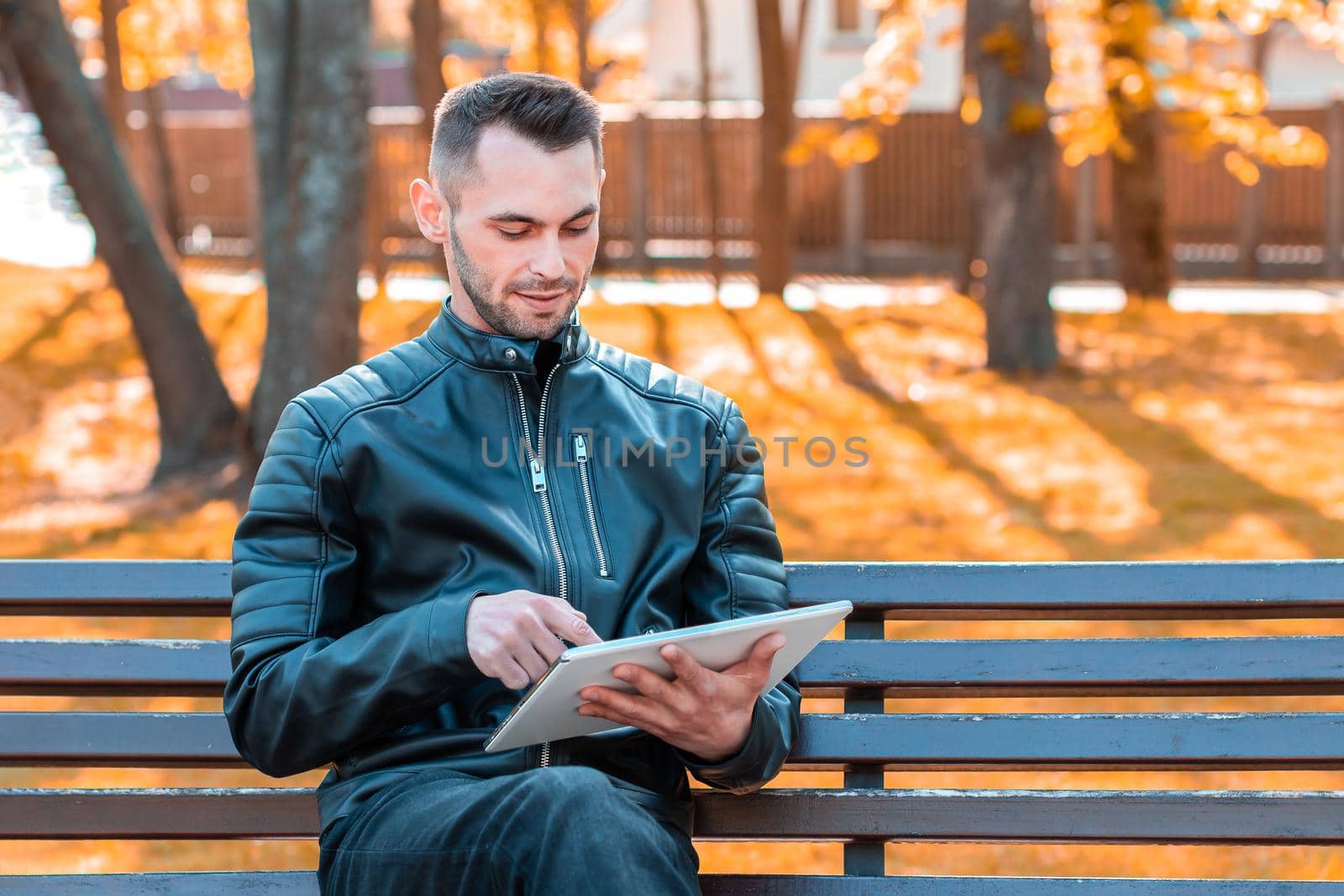 Youthful Guy Sitting on the Bench with Tablet PC by InfinitumProdux