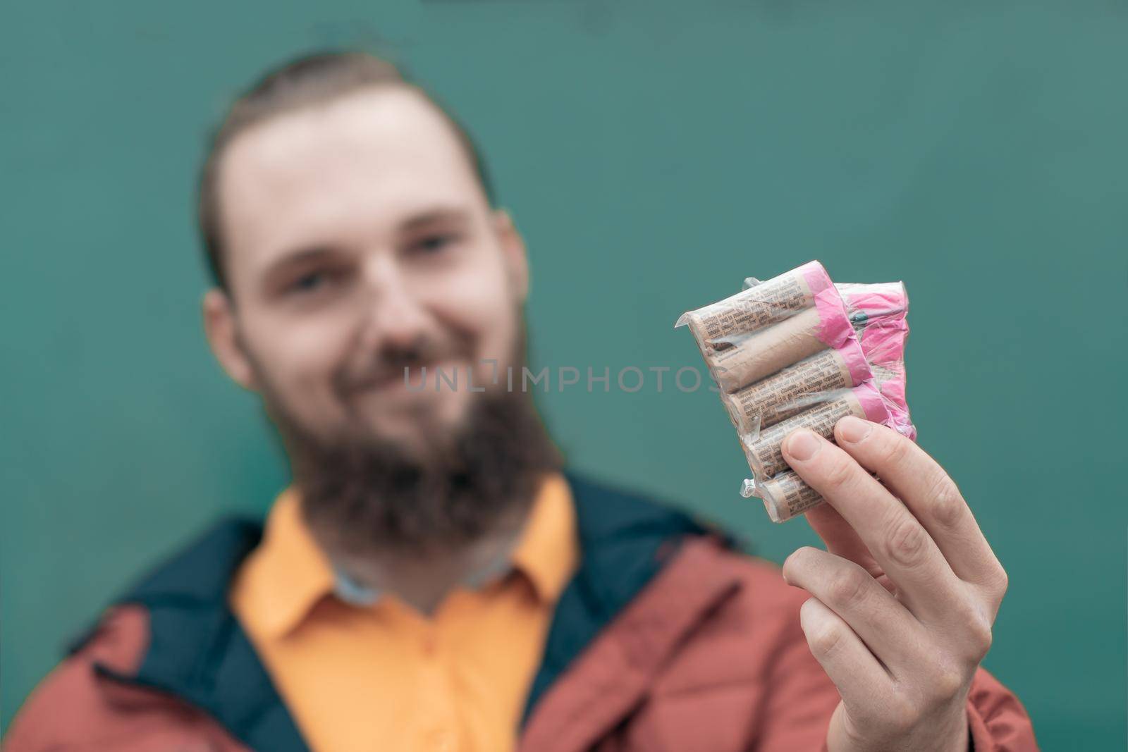 Happy Young Man Holding Firecrackers in his Hand. Bearded Guy Getting Ready for New Year Fun
