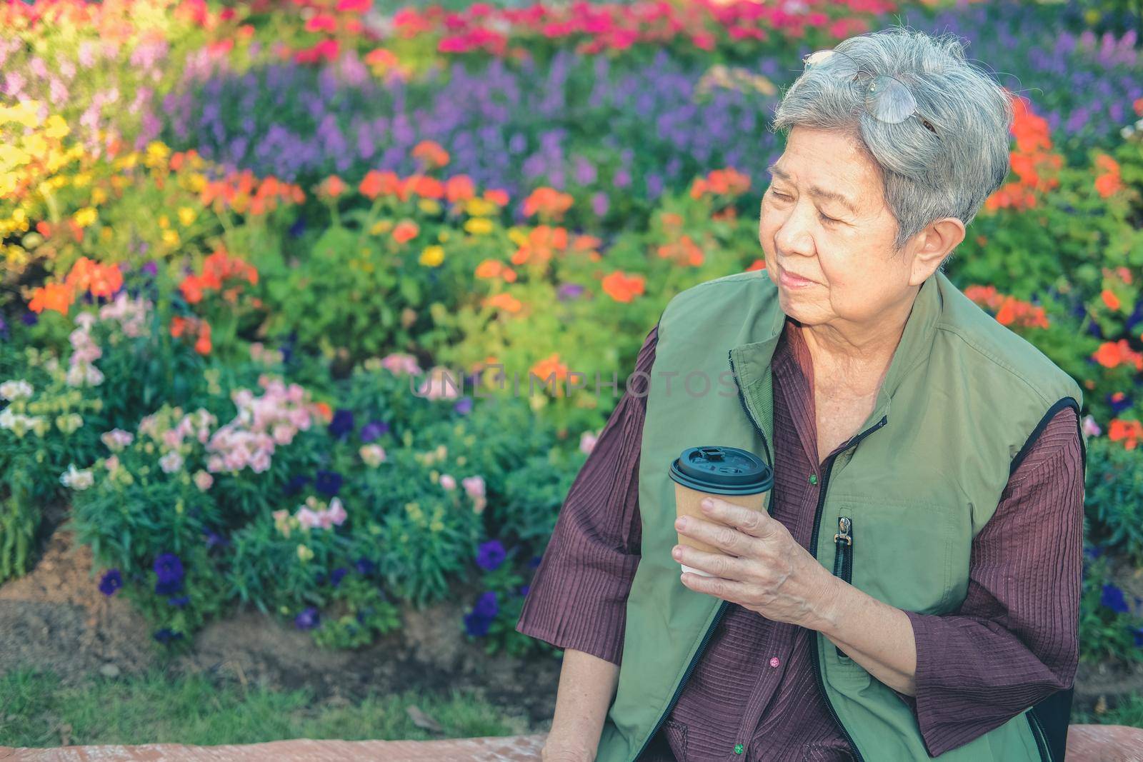 asian old elderly female elder woman drinking coffee tea in garden. senior leisure lifestyle