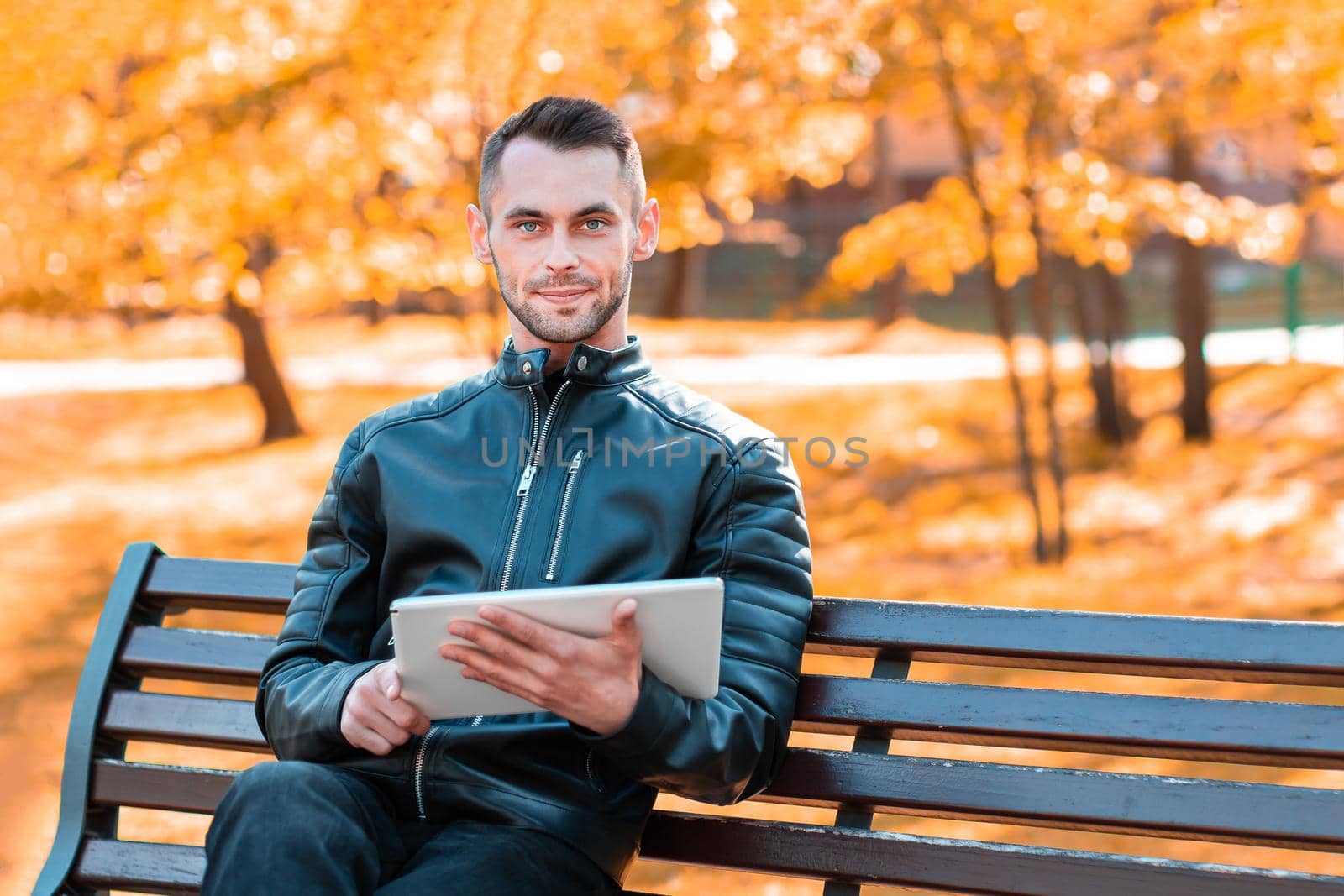 Youthful Guy Sitting on the Bench with Tablet PC by InfinitumProdux
