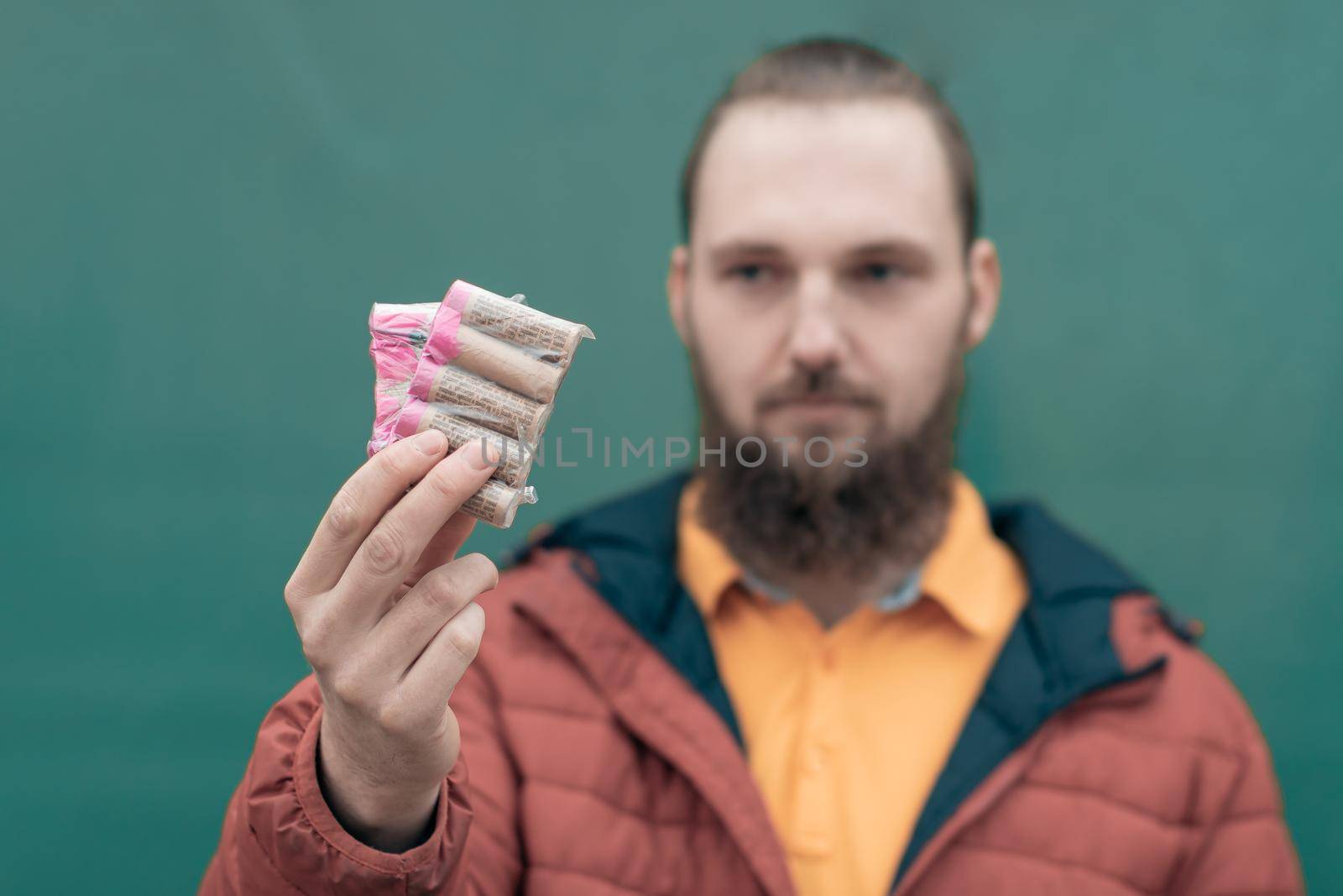 Serious Young Man Holding Firecrackers in his Hand. Bearded Guy Getting Ready for New Year Fun