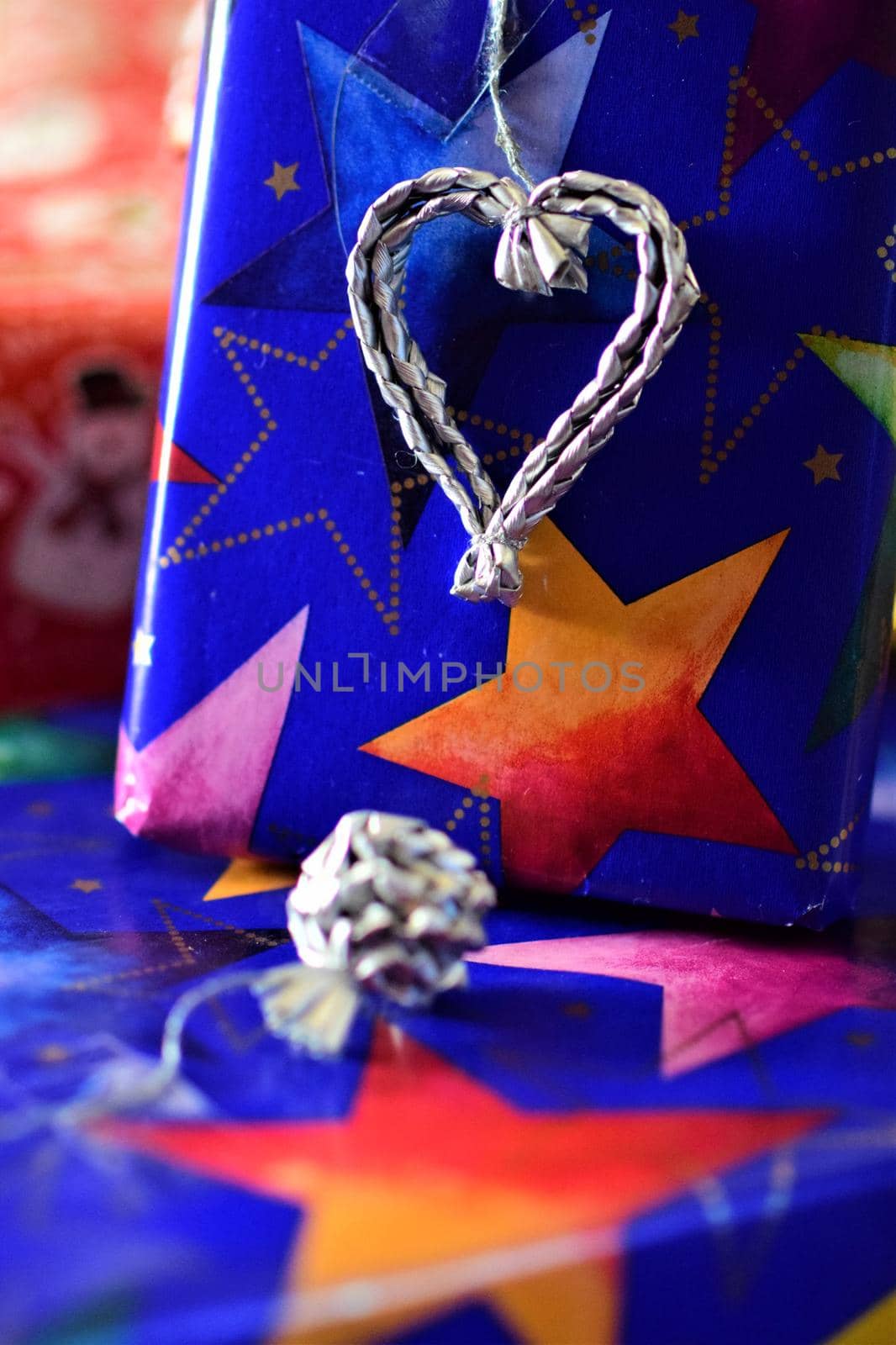 Close up of colorful christmas gifts with a silver colored heart by Luise123