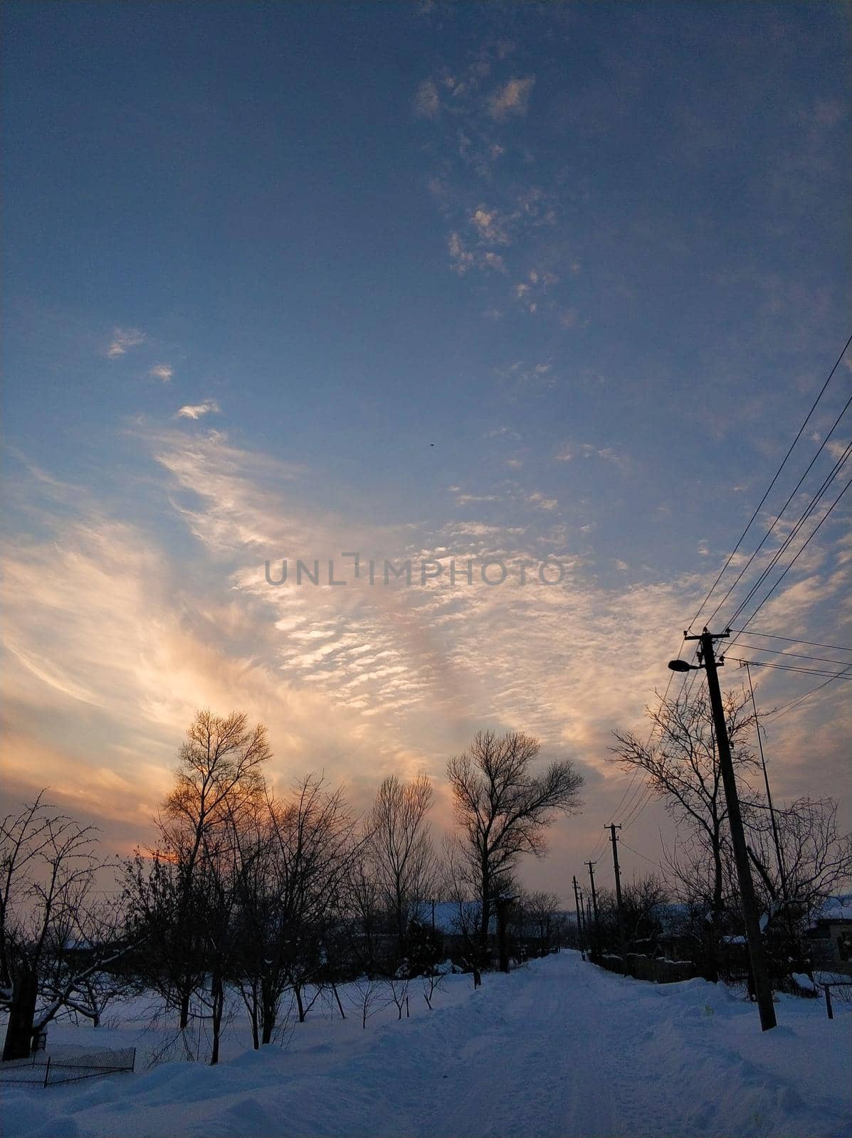 Winter landscape. A distant village in the cold part of the planet. White snow covered road.