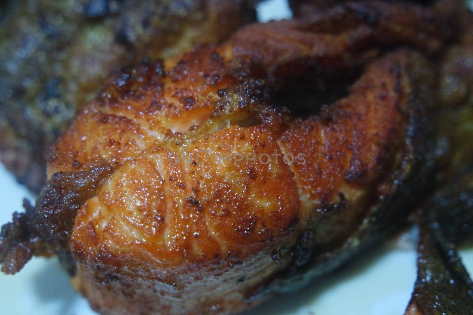 Spicy and crunchy barbecue of fried fish fillet on a white background. Homemade grilled trout fish steaks for health nourishments.