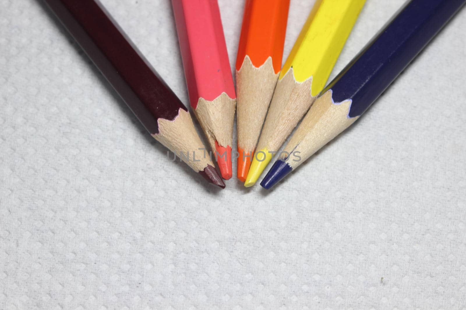 Close-up view of bright colored multicolor pencils on black background