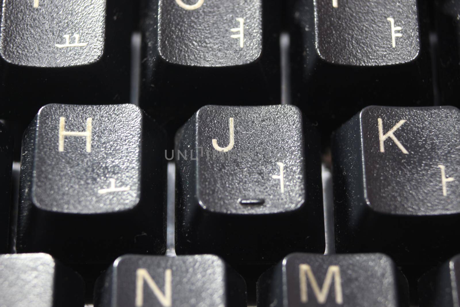 Closeup of laptop computer keyboard black keys with white letters and numbers. Black keys with white characters.