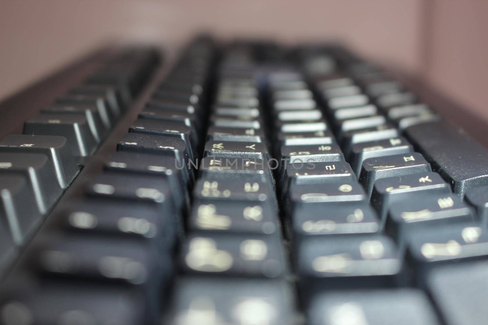 Closeup of laptop computer keyboard black keys with white letters and numbers. Black keys with white characters.