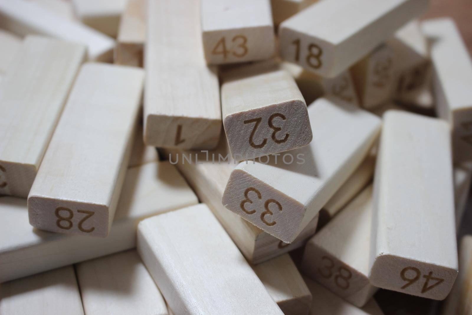 Pile of wooden blocks with engraved letters dispersed on floor. Children toy for building creative works.