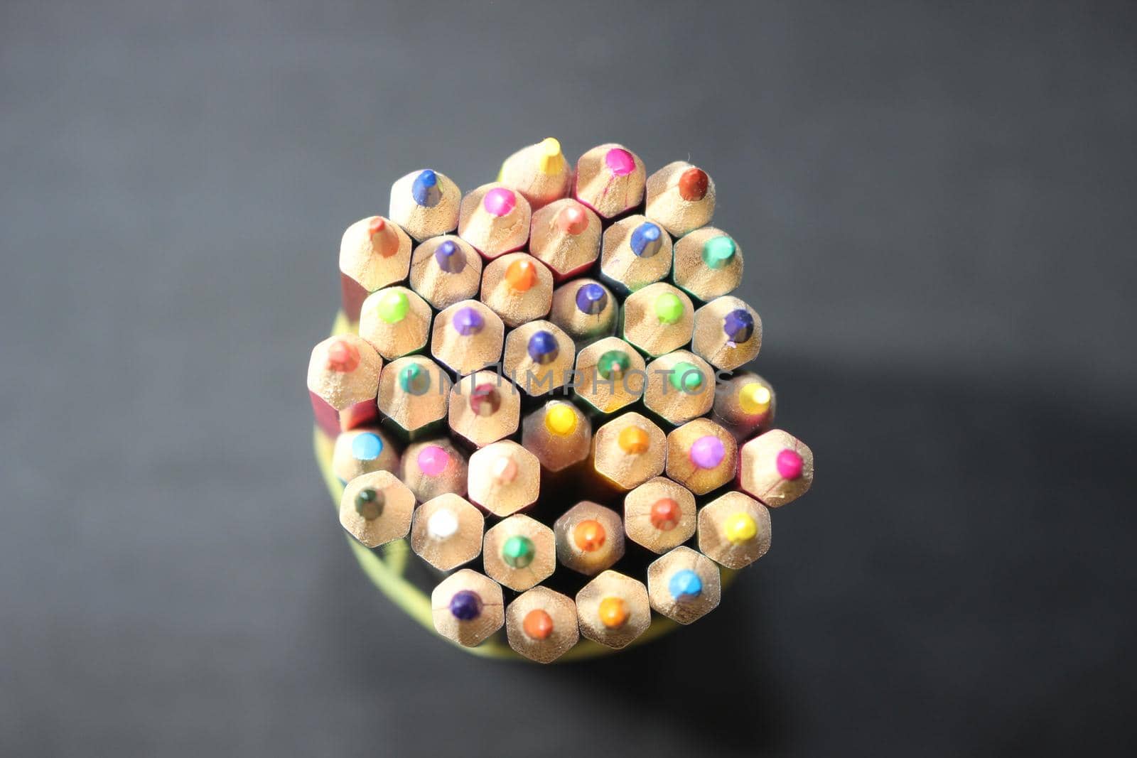 Close-up view of bright colored multicolor pencils on black background