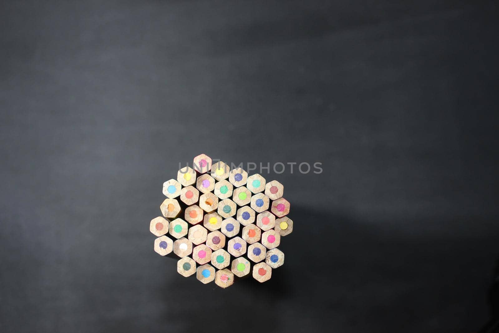 Close-up view of bright colored multicolor pencils on black background