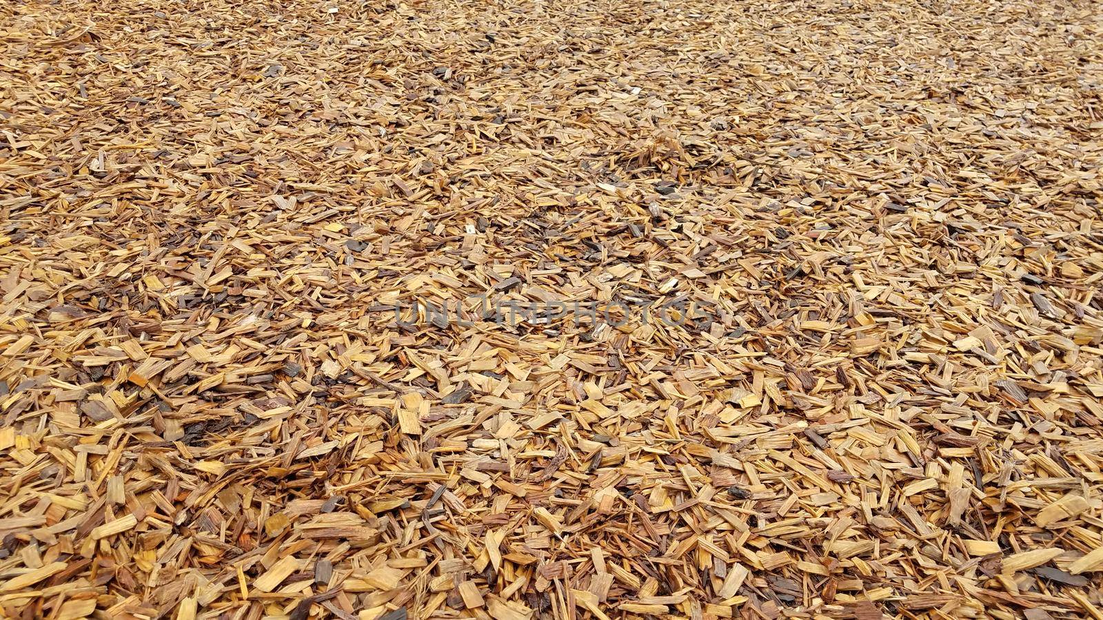 brown damp wood chips or mulch or barkdust on ground