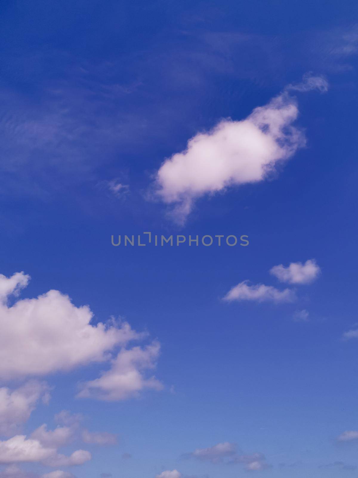 Vertical shot of a blue cloudy sky on a sunny day - great for wallpapers