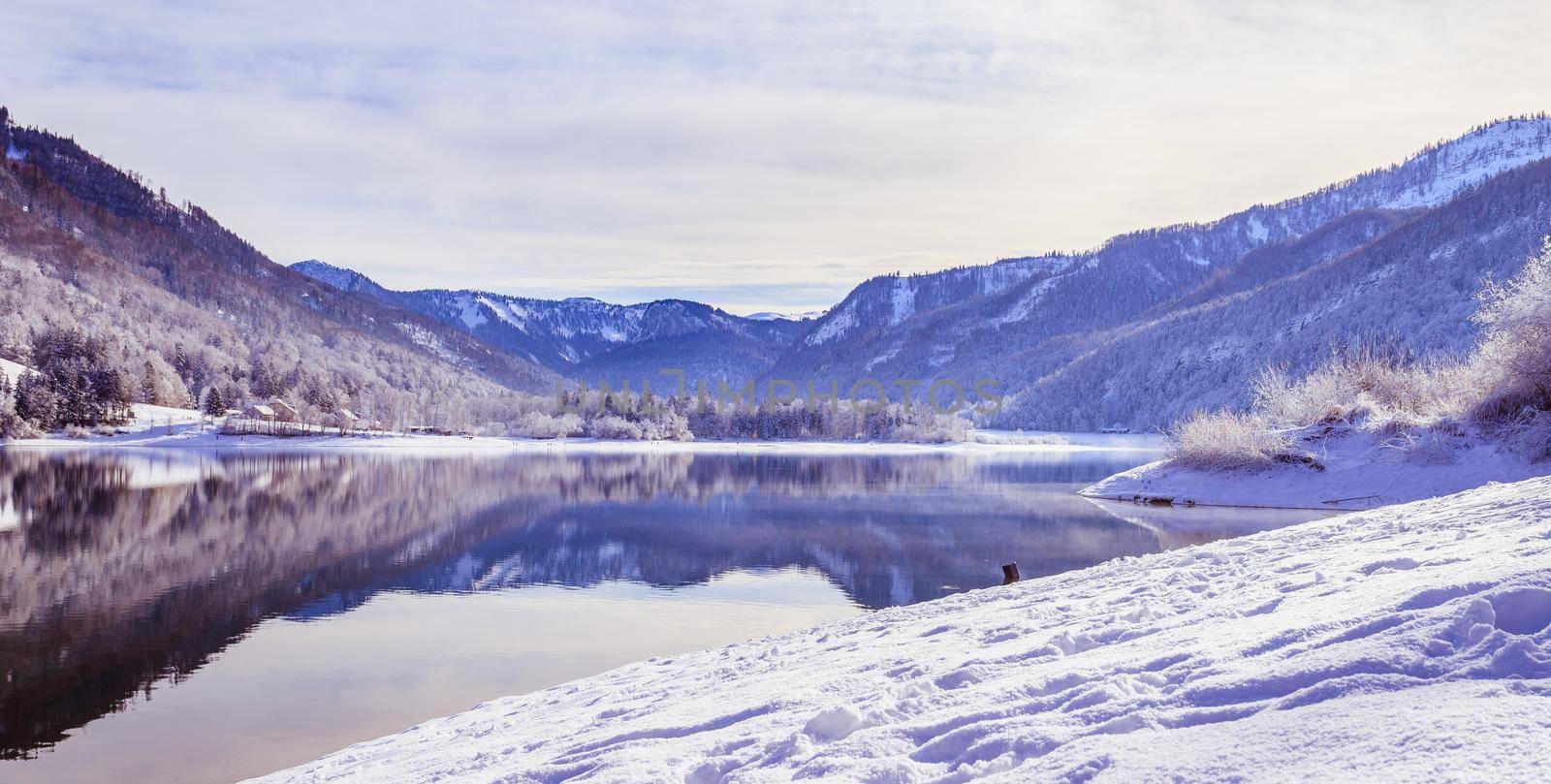 Idyllic winter landscape: Reflection lake, snowy trees and mountains