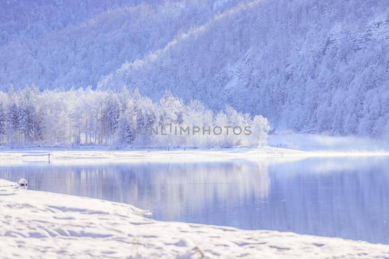 Idyllic winter landscape: Reflection lake, snowy trees and mountains