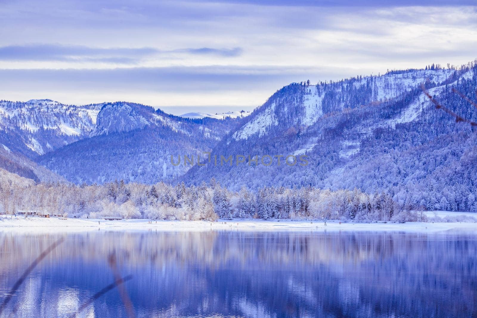 Idyllic winter landscape: Reflection lake, snowy trees and mountains